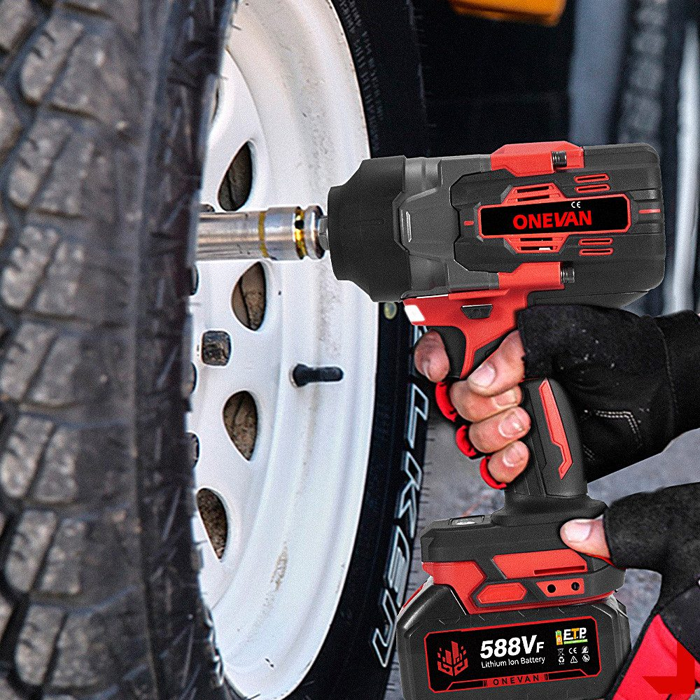 Hand hält ein rot-schwarzes Elektrowerkzeug in der Nähe eines Autoreifens und einer weißen Felge.