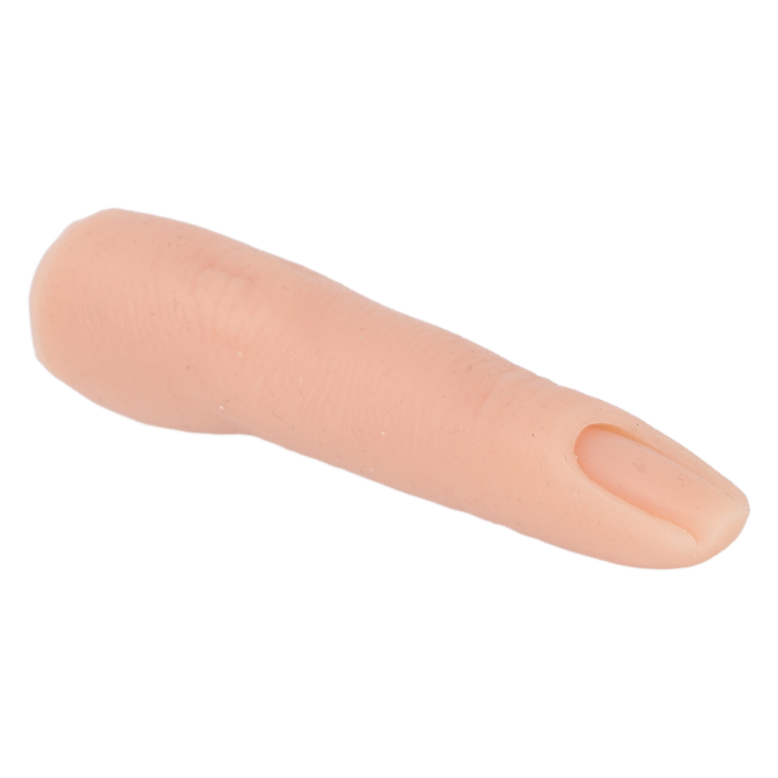 Ein fleischfarbener Prothesenfinger liegt auf einer weißen Oberfläche, die Spitze zeigt nach rechts.