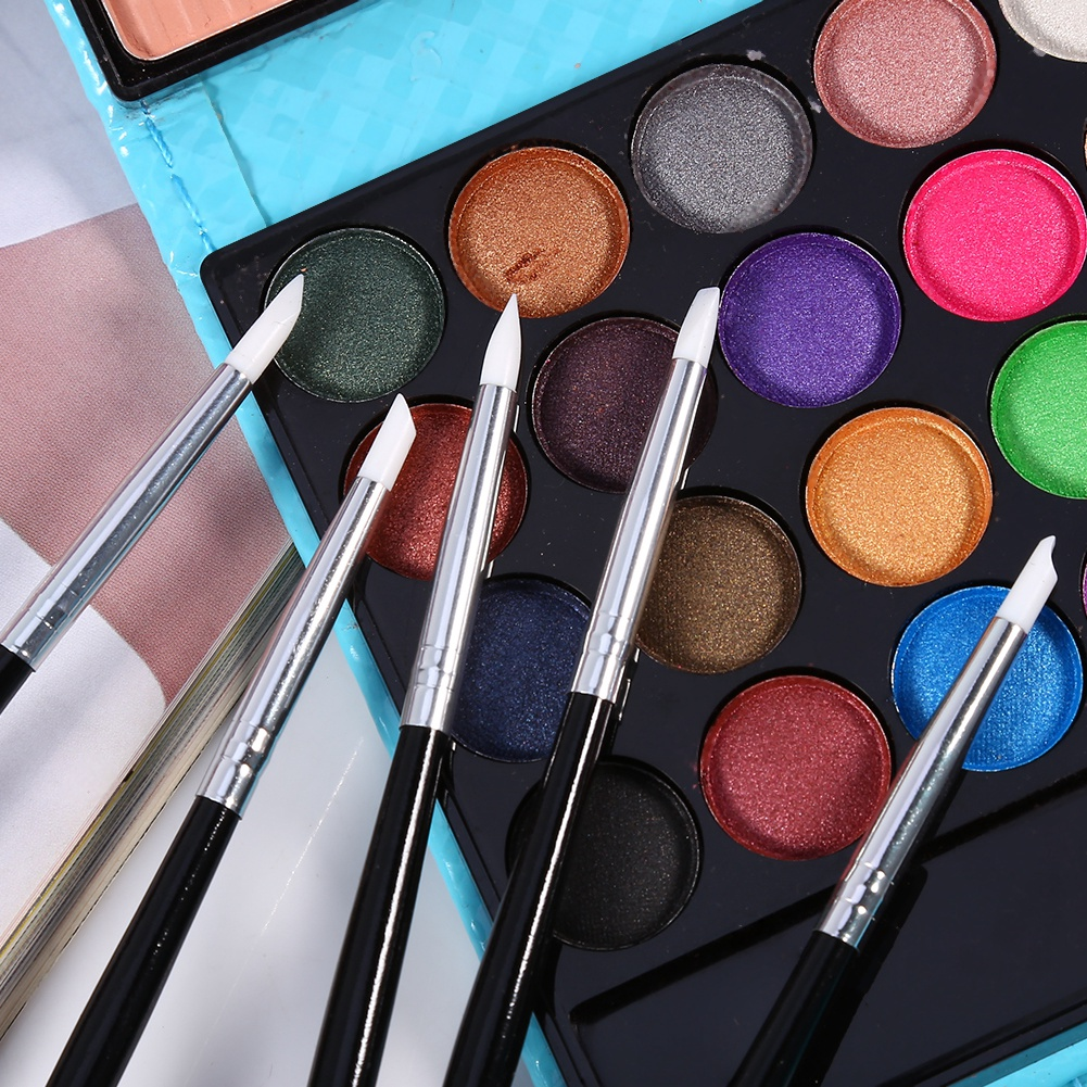 Nagelkunstpinsel und eine Make-up-Palette mit verschiedenen Lidschattenfarben.