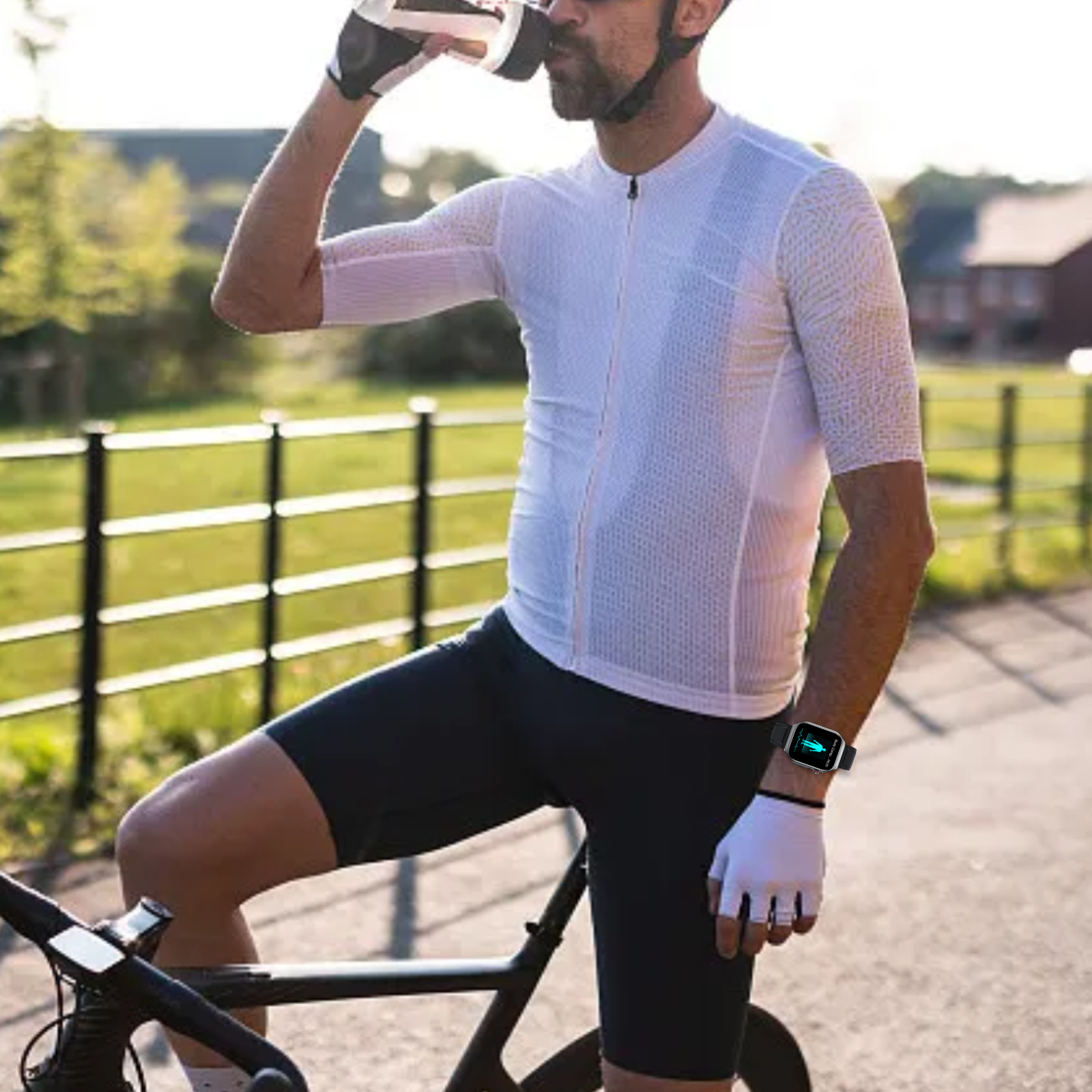 Ein Radfahrer trinkt aus einer Flasche, während er neben einem Fahrrad steht. Er trägt Handschuhe und Helm, auf einer Straße.