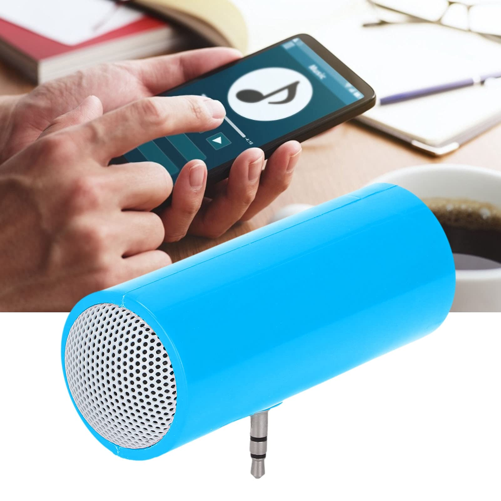 Ein blauer zylindrischer Lautsprecher mit silbernem Gitter ist vor einem Smartphone abgewinkelt. Das Telefon zeigt Musiksteuerungen.