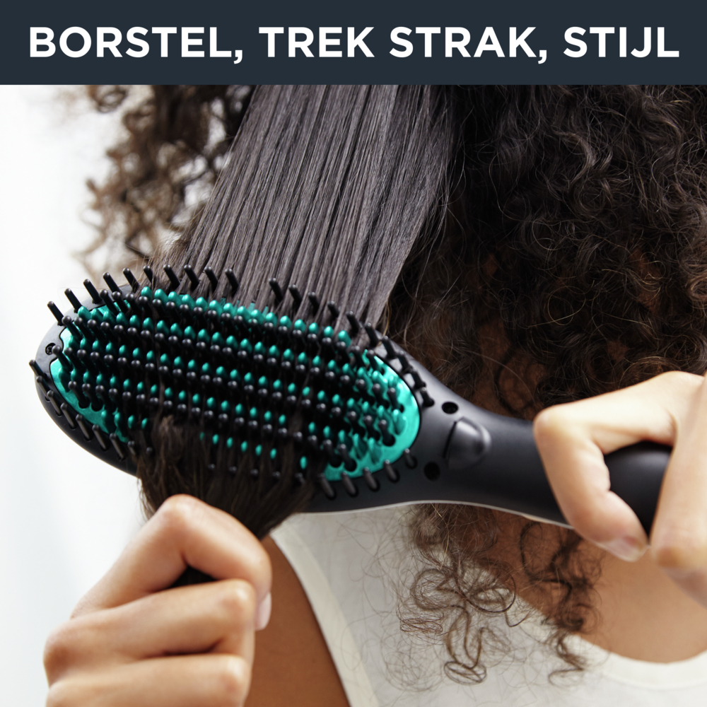 A person is using a hair straightening brush on dark, curly hair. The brush is black and teal.