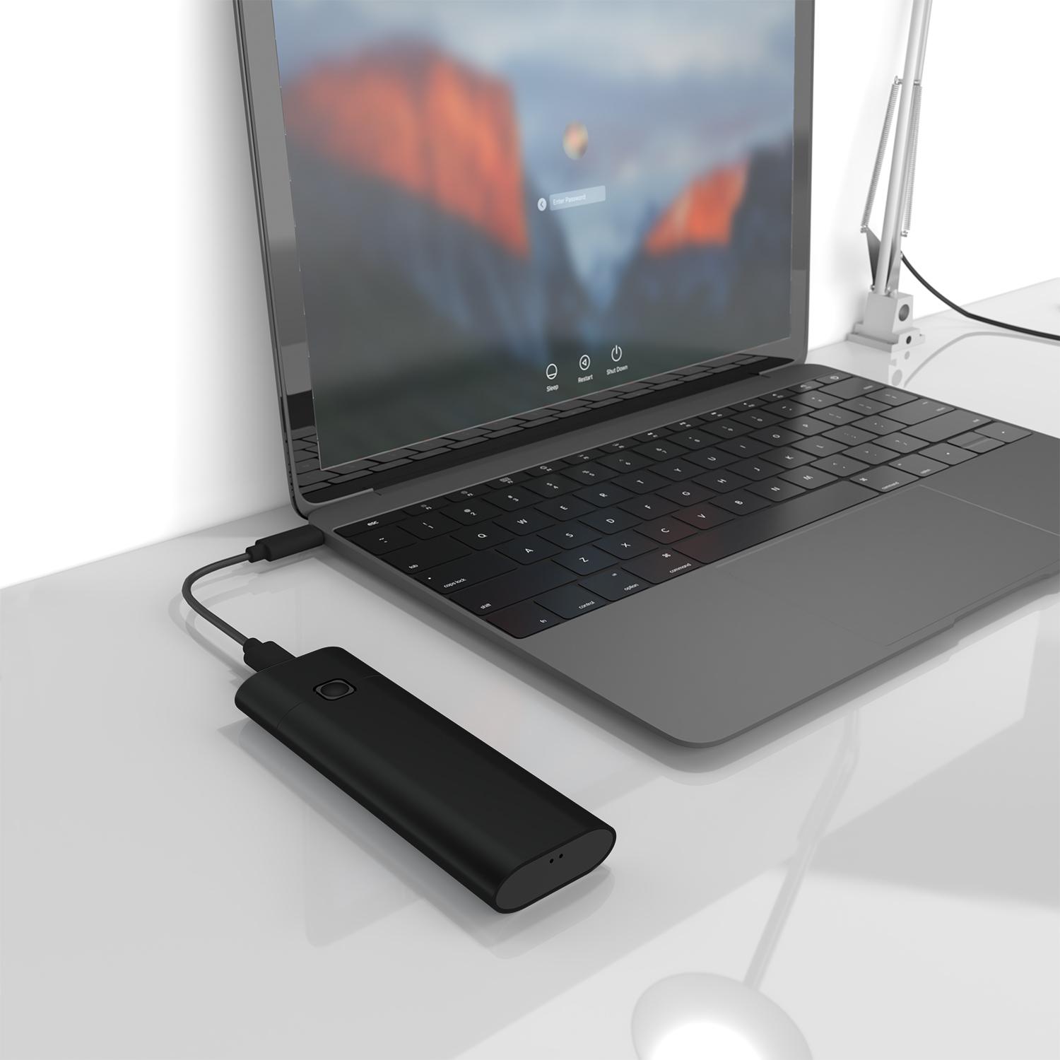 Un dispositivo rettangolare nero è collegato a un laptop su una scrivania bianca. Il laptop mostra una richiesta di accesso.