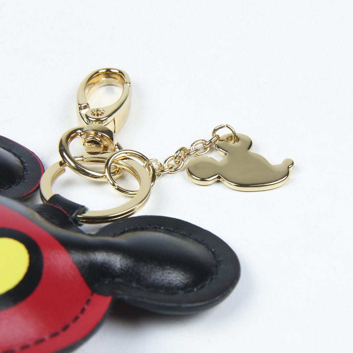 Llavero de Mickey Mouse dorado con detalles en negro y rojo.