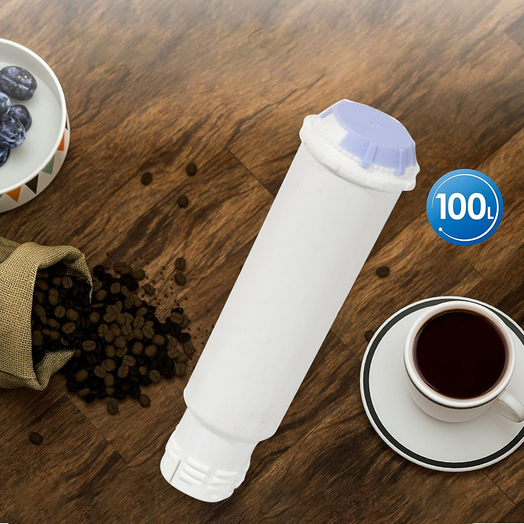 Ein weißer Wasserfilter mit blauem Deckel, Kaffeebohnen und eine Tasse Kaffee auf einem Holztisch.