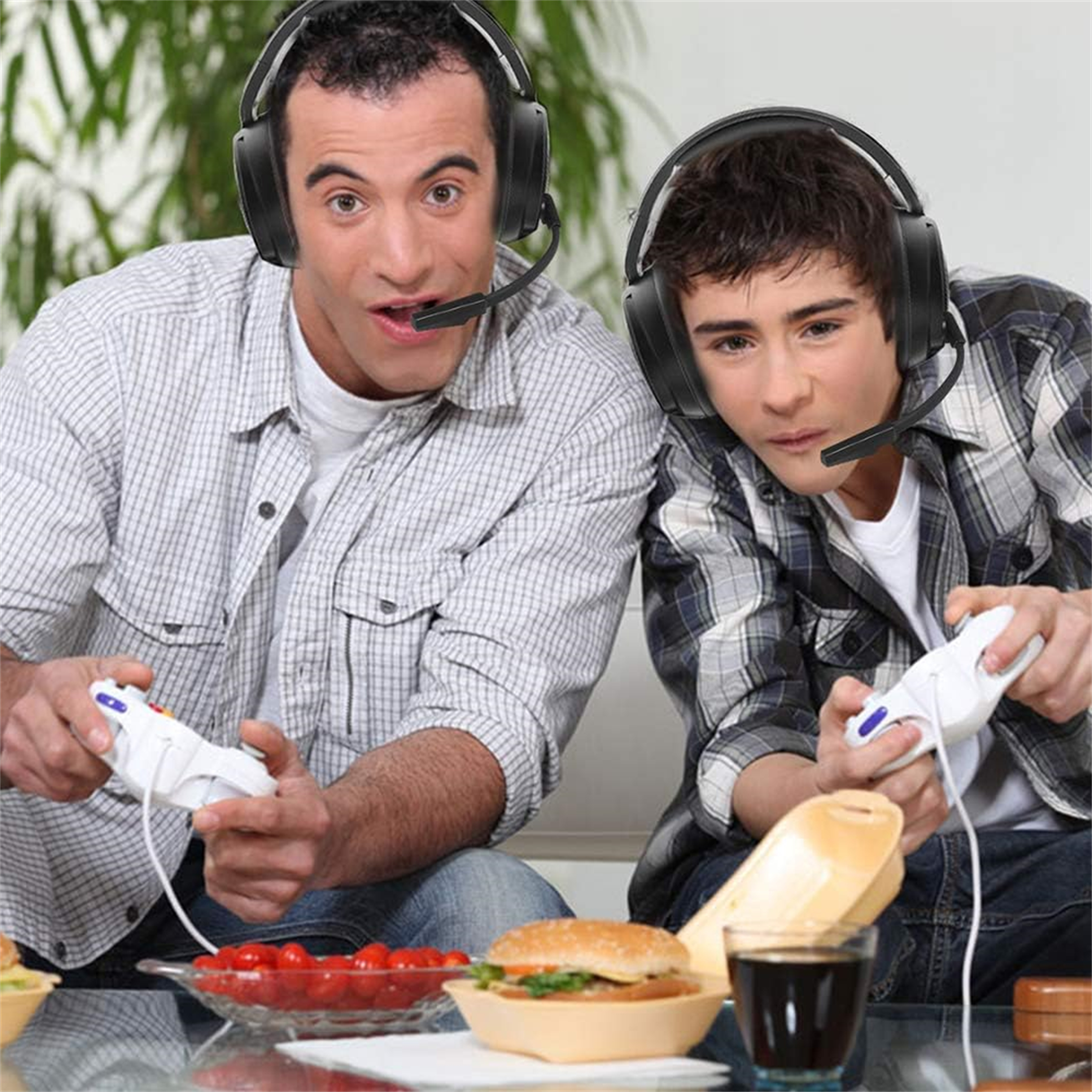 Zwei Männer spielen mit Headsets und Controllern ein Spiel. Essen und Trinken im Vordergrund.