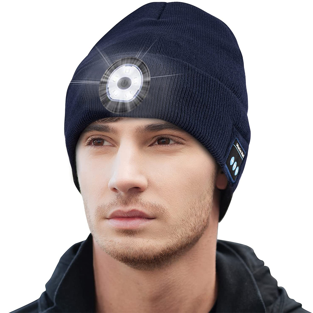 Ein Mann trägt eine marineblaue Mütze mit eingebautem Licht und Bluetooth-Tasten. Der Hintergrund ist weiß.