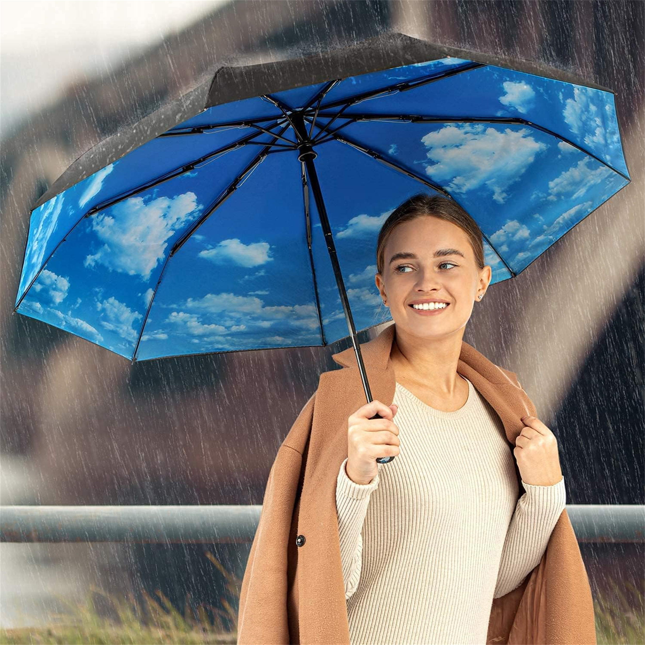 Frau hält Regenschirm mit blauem Himmel und Wolkenmuster, trägt Mantel im Regen.
