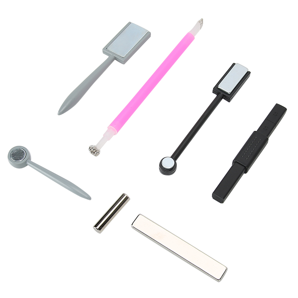 Nail-Art-Werkzeuge auf weißem Hintergrund. Verschiedene Formen und Größen. Graue, rosa, schwarze Werkzeuge sind gezeigt.