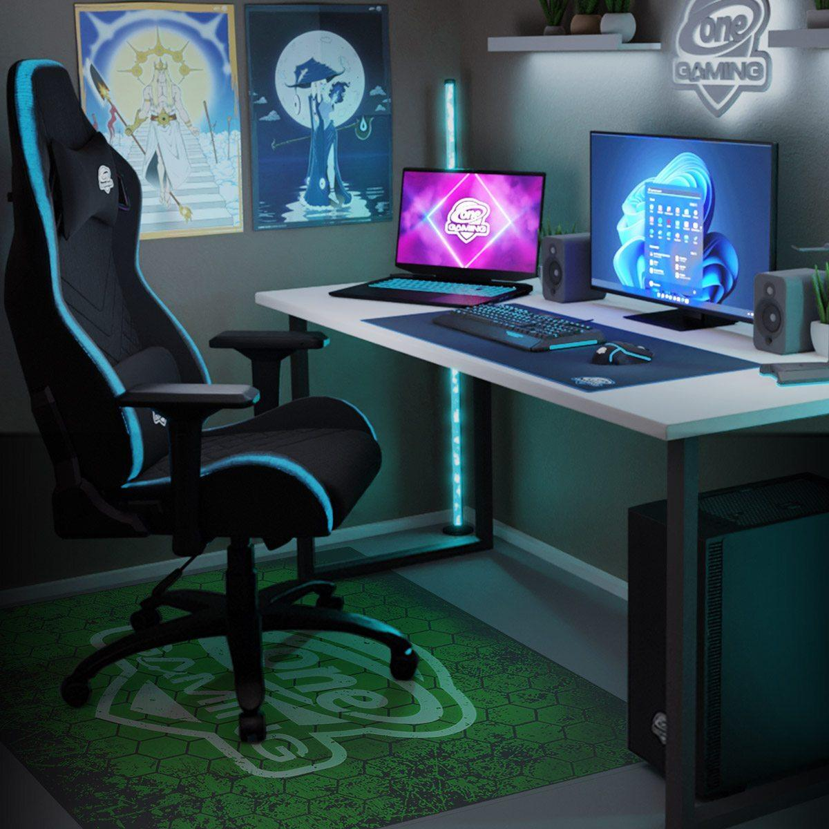 Gaming-Setup: Stuhl, Schreibtisch mit Monitoren, Tastatur, Maus, Lautsprecher und PC. Poster an der Wand. Grüne Gaming-Matte.