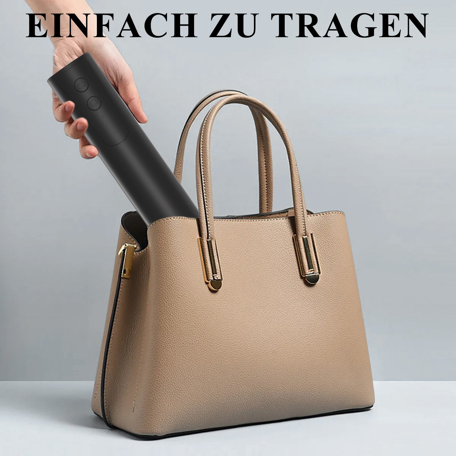Hand legt schwarzen Zylinder in beige Handtasche, vor grauem Hintergrund.