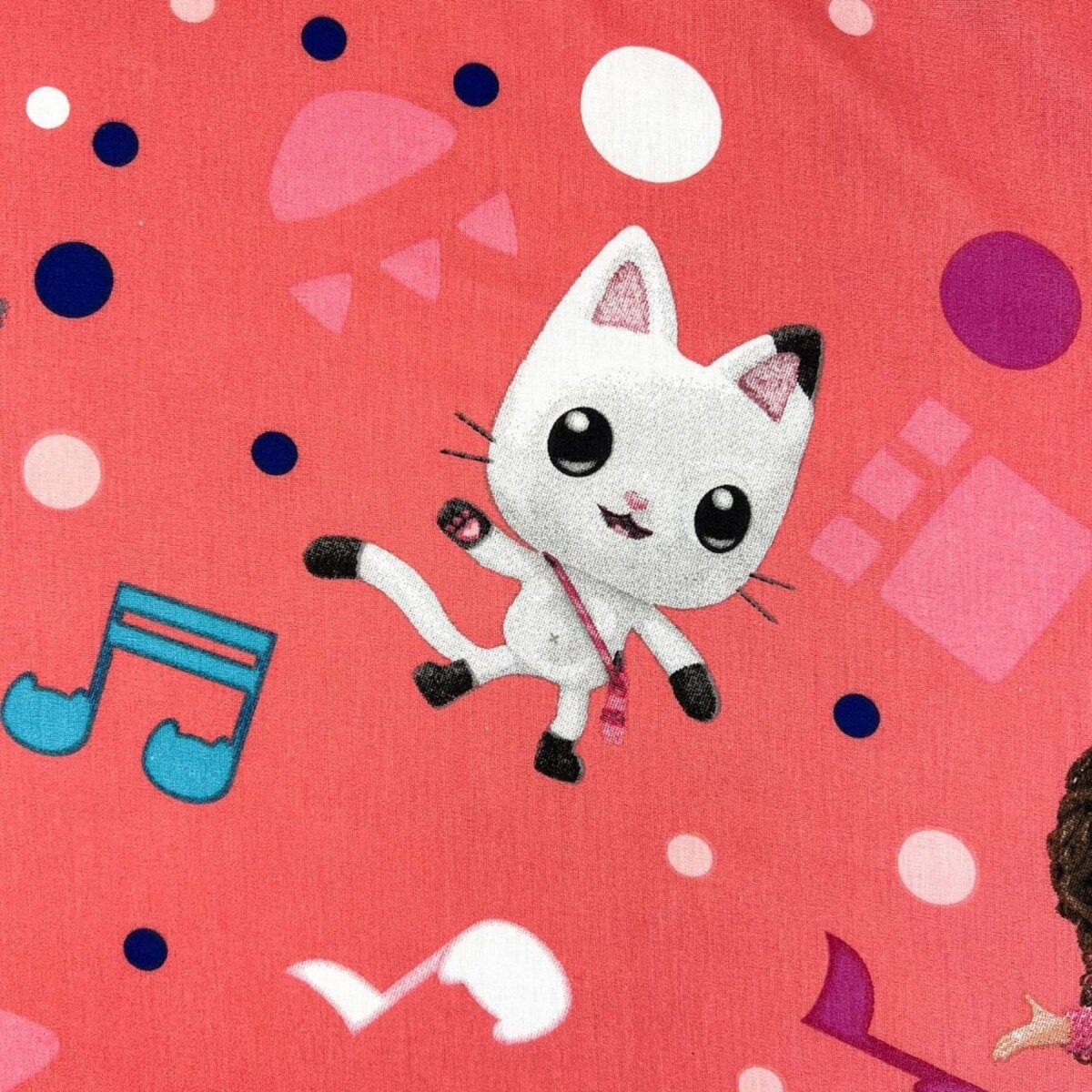 Ein rosa Stoff mit einer Cartoon-Katzenfigur und Noten darauf verstreut.