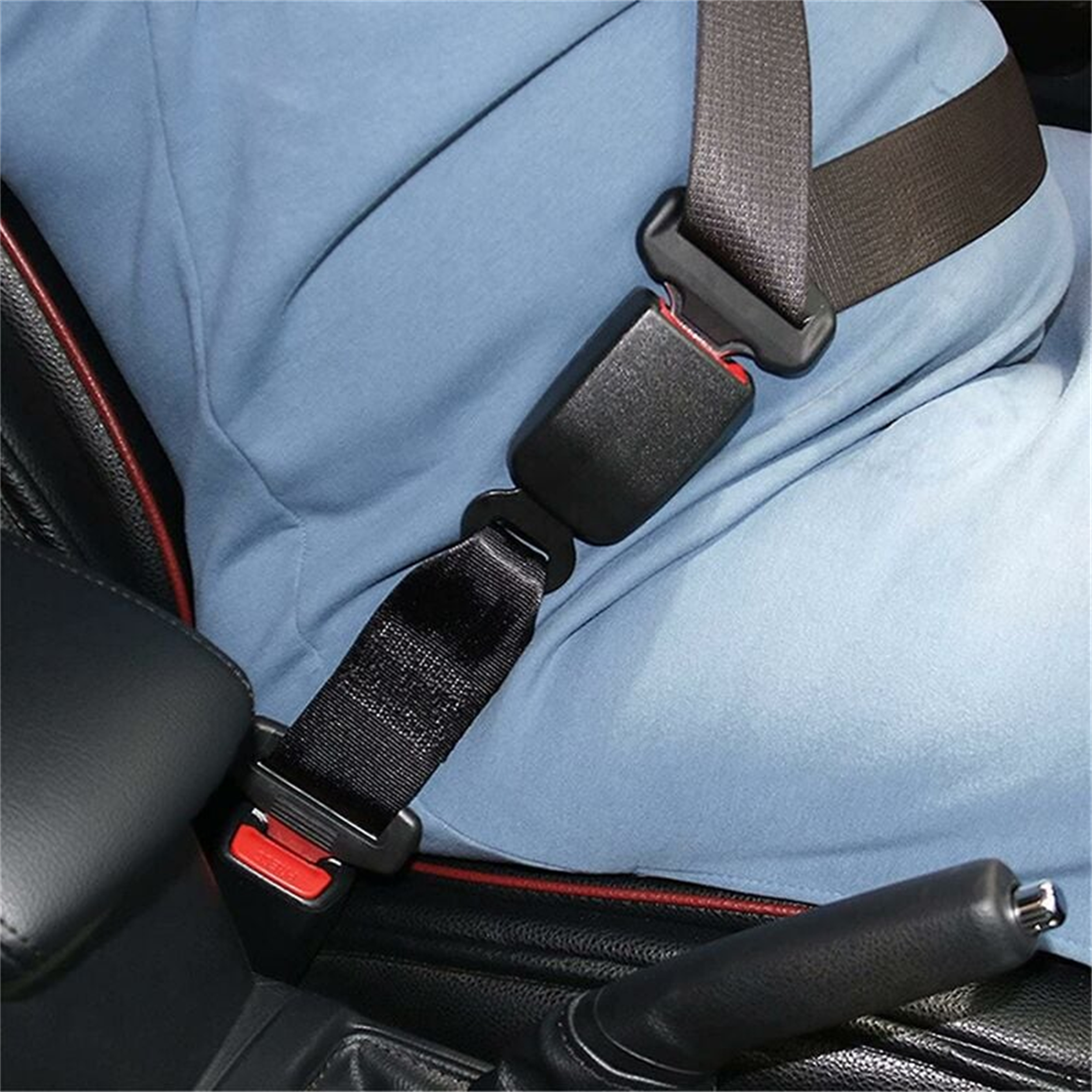 Eine Person in einem blauen Hemd trägt einen schwarzen Sicherheitsgurt in einem Auto. Rote Verkleidung ist zu sehen.