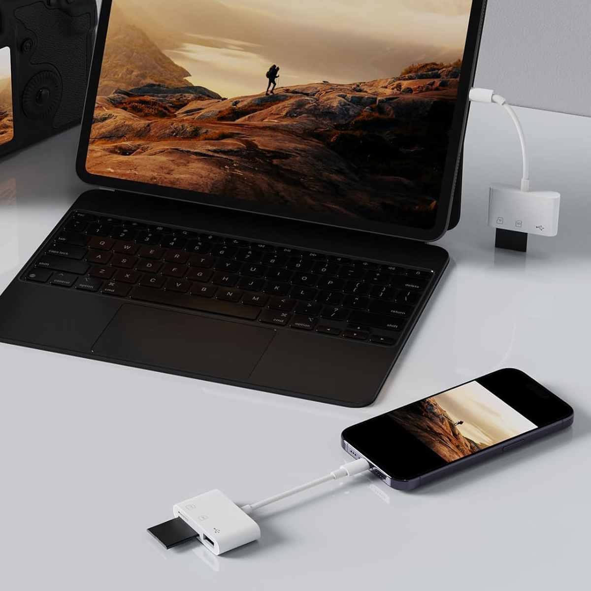 Ein Laptop und ein Telefon sind mit einem weißen USB-Kartenleser verbunden. In das Lesegerät ist eine SD-Karte eingesetzt.