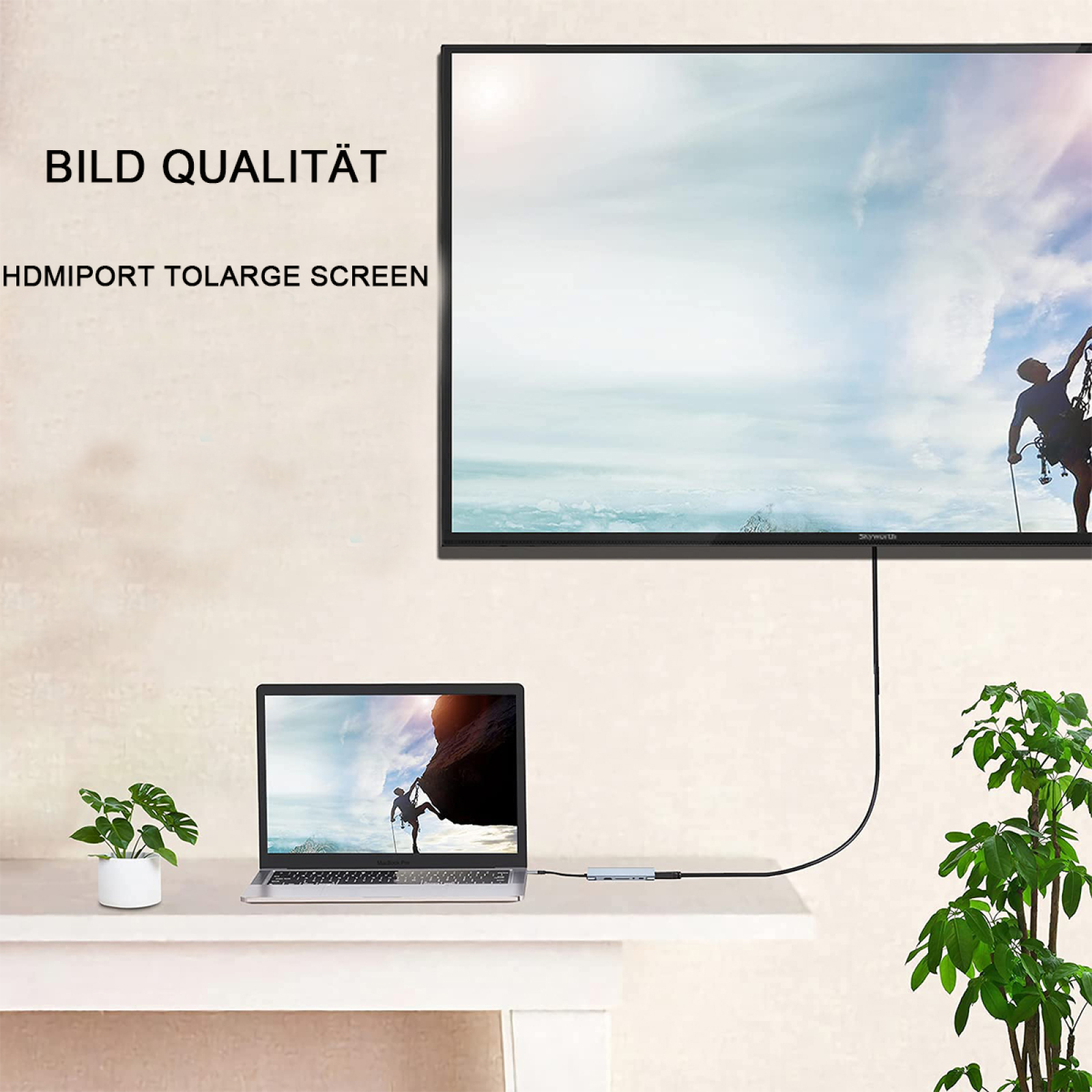 Un laptop collegato a una TV a schermo grande. Una persona scala una montagna su entrambi gli schermi.