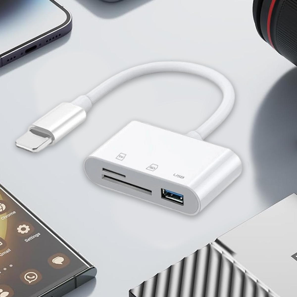 Un lettore di schede bianco con cavo USB, un telefono e un laptop sono su una superficie bianca.