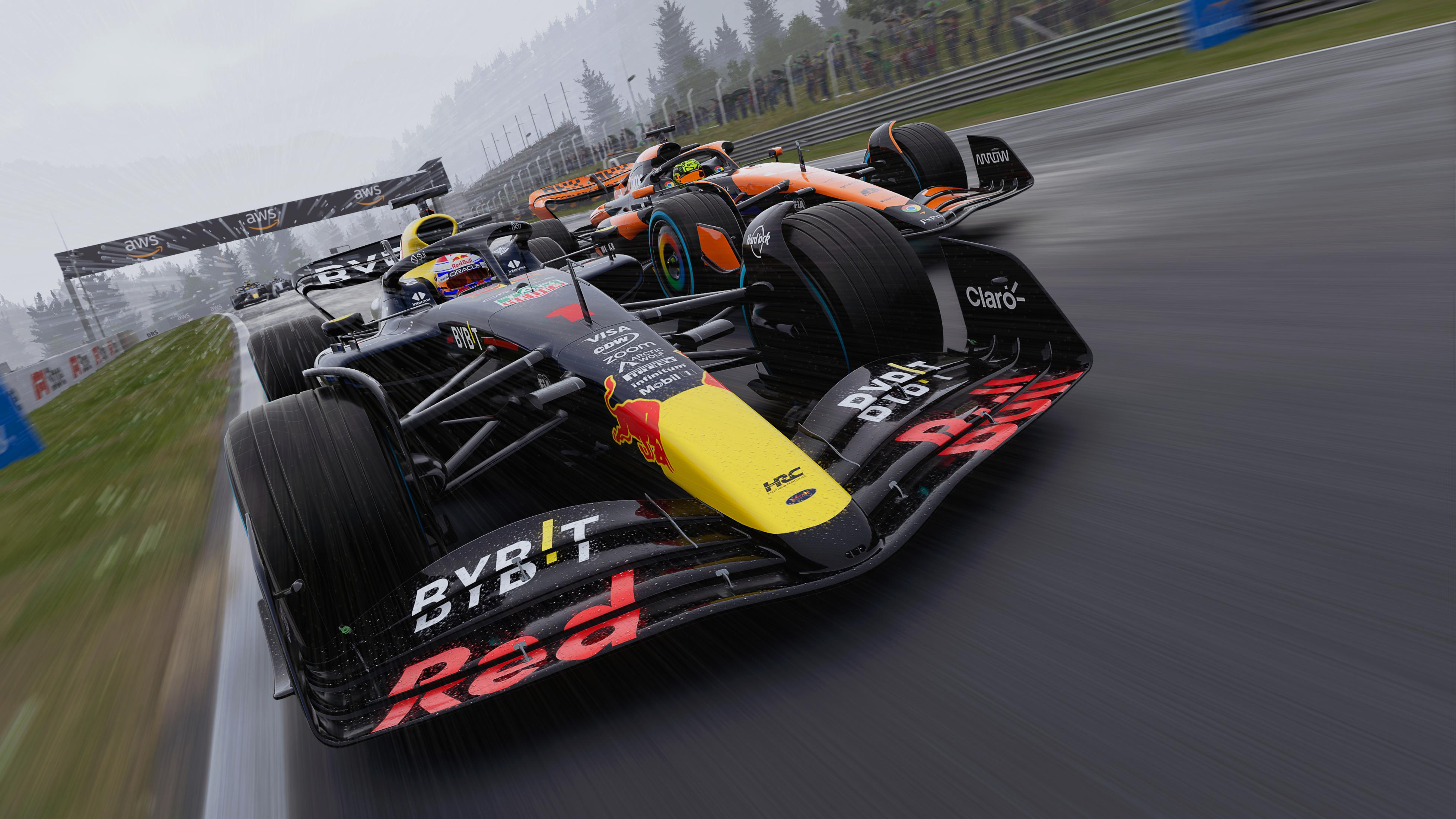 Zwei F1-Rennwagen fahren bei Regen auf einer Rennstrecke. Das Red Bull-Auto ist vorne.