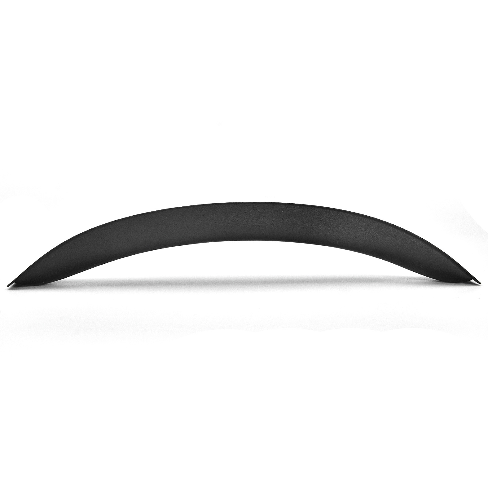 Un pezzo di plastica nero curvo contro uno sfondo bianco, visto da un'angolazione bassa.