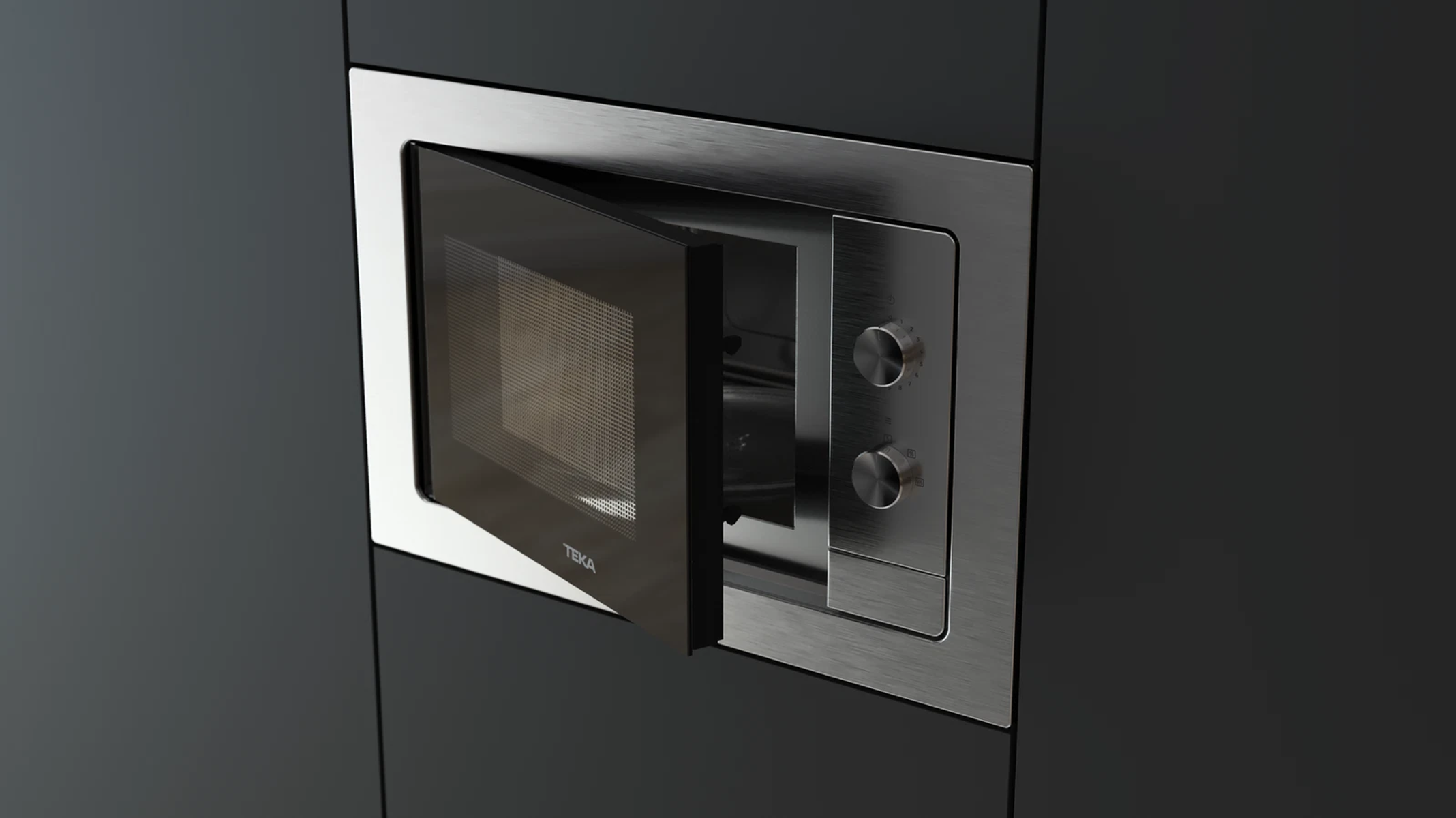Kuchenka mikrofalowa TEKA w ciemnej szafce z lekko otwartymi drzwiami.
