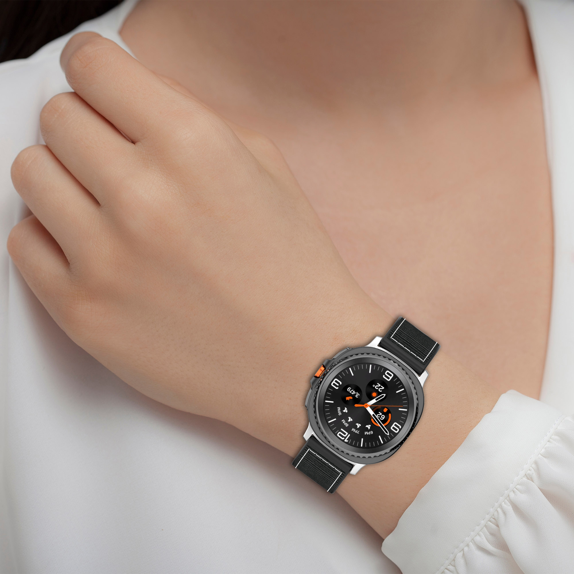 Das Handgelenk einer Frau mit einer Smartwatch, die Zeit und Statistiken anzeigt. Die Uhr hat ein schwarzes Armband.