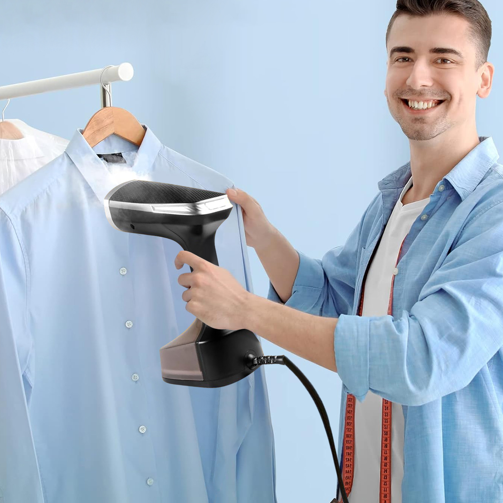 Ein Mann, der ein blaues Hemd mit einem schwarzen Handdampfer bügelt. Weiße Hemden hängen im Hintergrund.