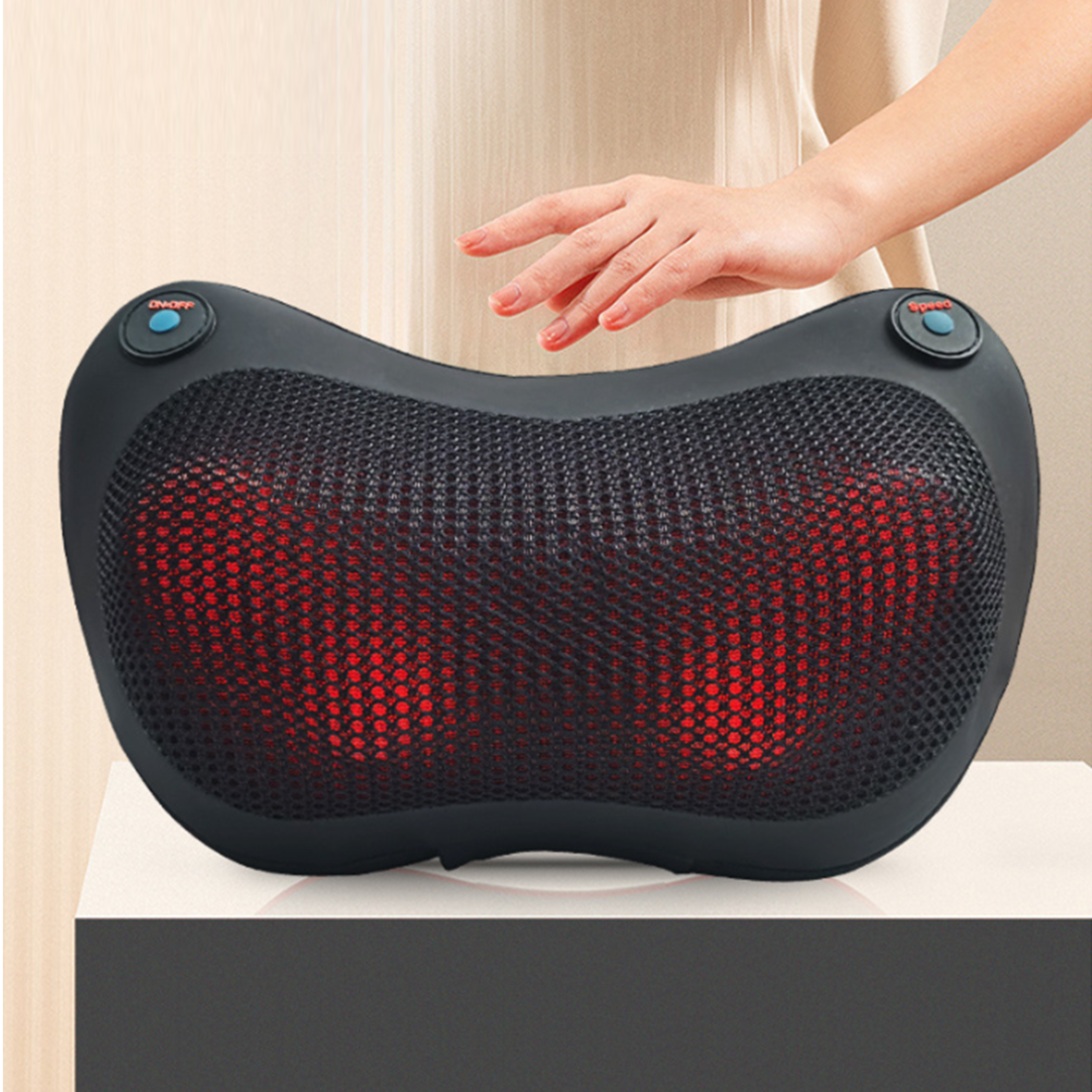 Die Hand einer Person berührt ein schwarzes Nackenmassagegerät mit rotem Netz. Es gibt Ein/Aus- und Geschwindigkeitstasten.