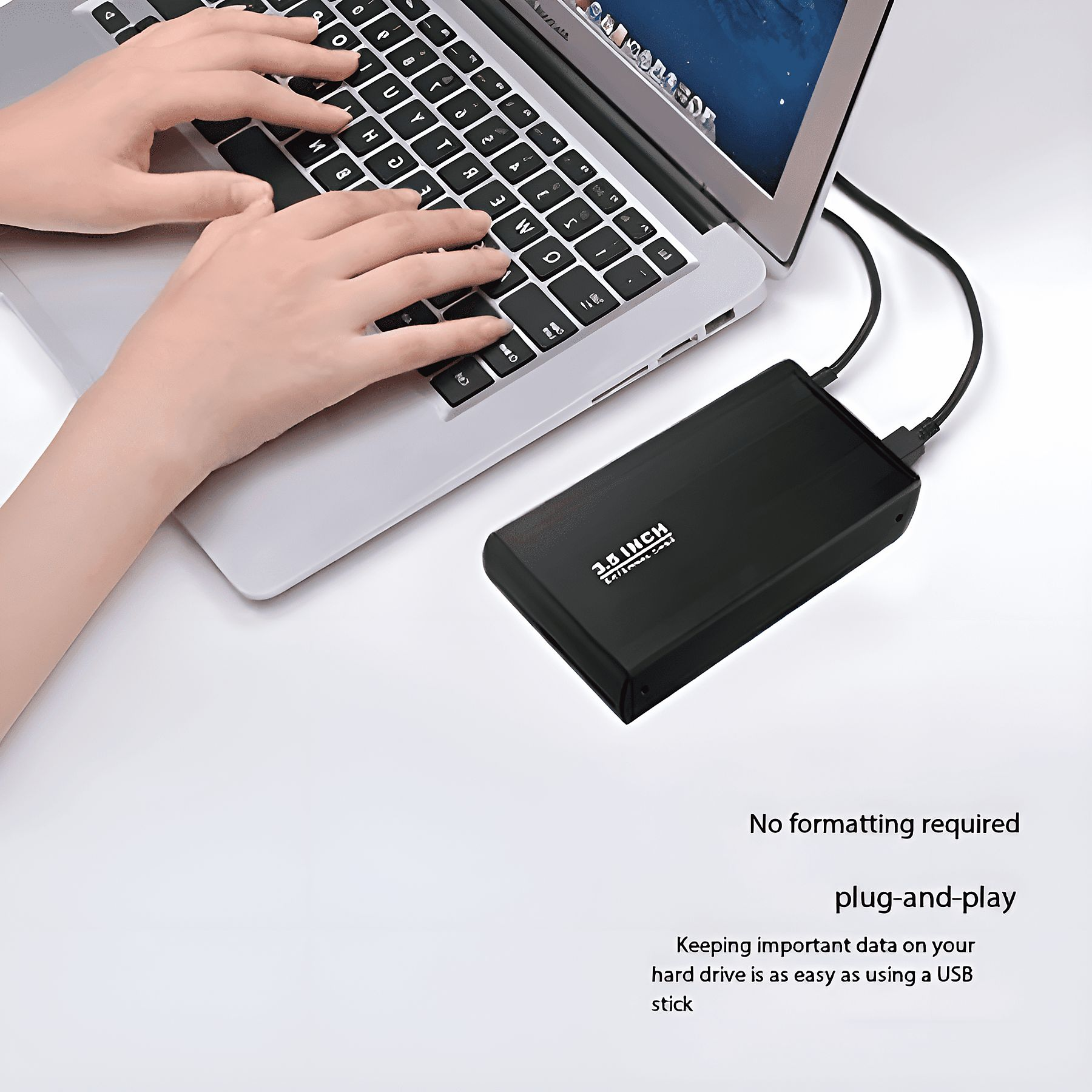 Eine Frau, die einen Laptop benutzt, mit einer angeschlossenen schwarzen externen Festplatte.