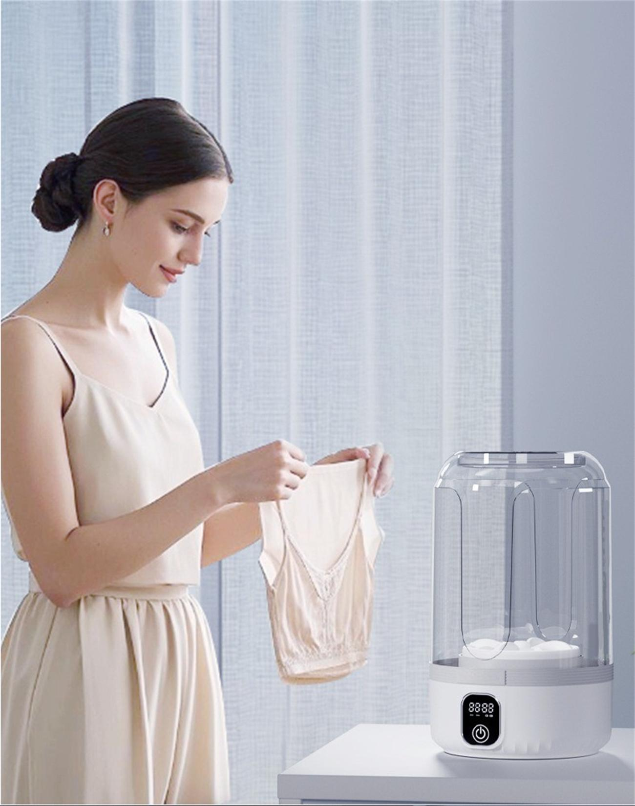 Eine Frau, die ein Kleidungsstück neben einem Wasserreiniger mit weißer Basis hält, einem transparenten Zylinder und Digitaldisplay.