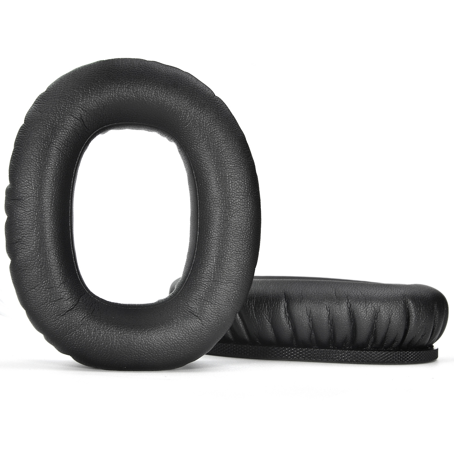 Vengono visualizzati due cuscinetti auricolari neri e rotondi per cuffie, uno in piedi e uno sdraiato, su uno sfondo bianco.