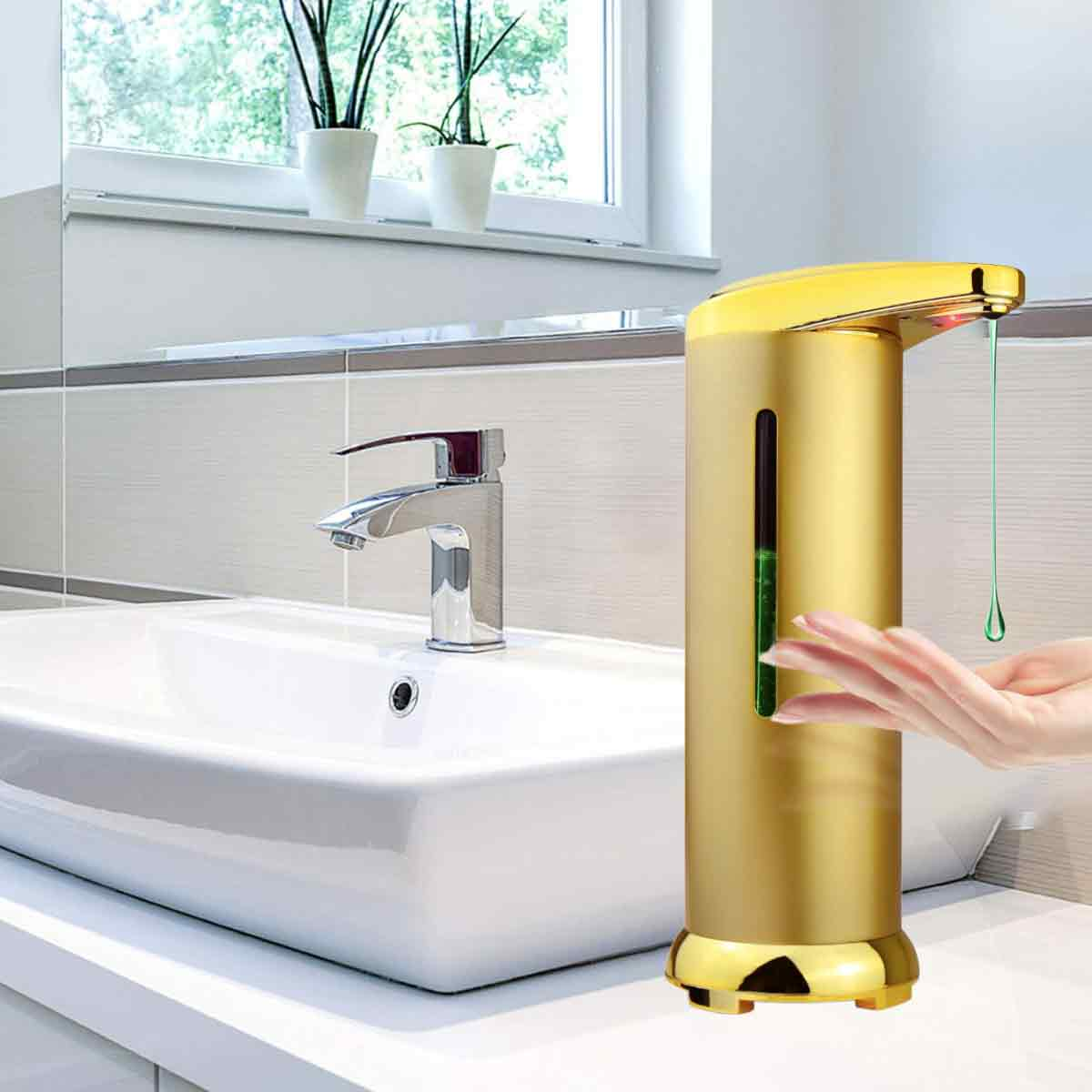 Goldener automatischer Seifenspender, der grüne Seife abgibt, mit Waschbecken im Hintergrund.