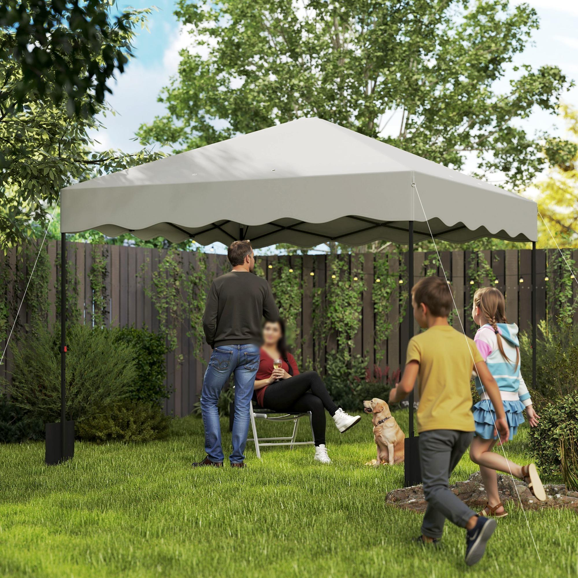 Eine Familie unter einem beigen Pop-up-Pavillon-Zelt in einem Garten. Kinder rennen; ein Hund ist dabei.