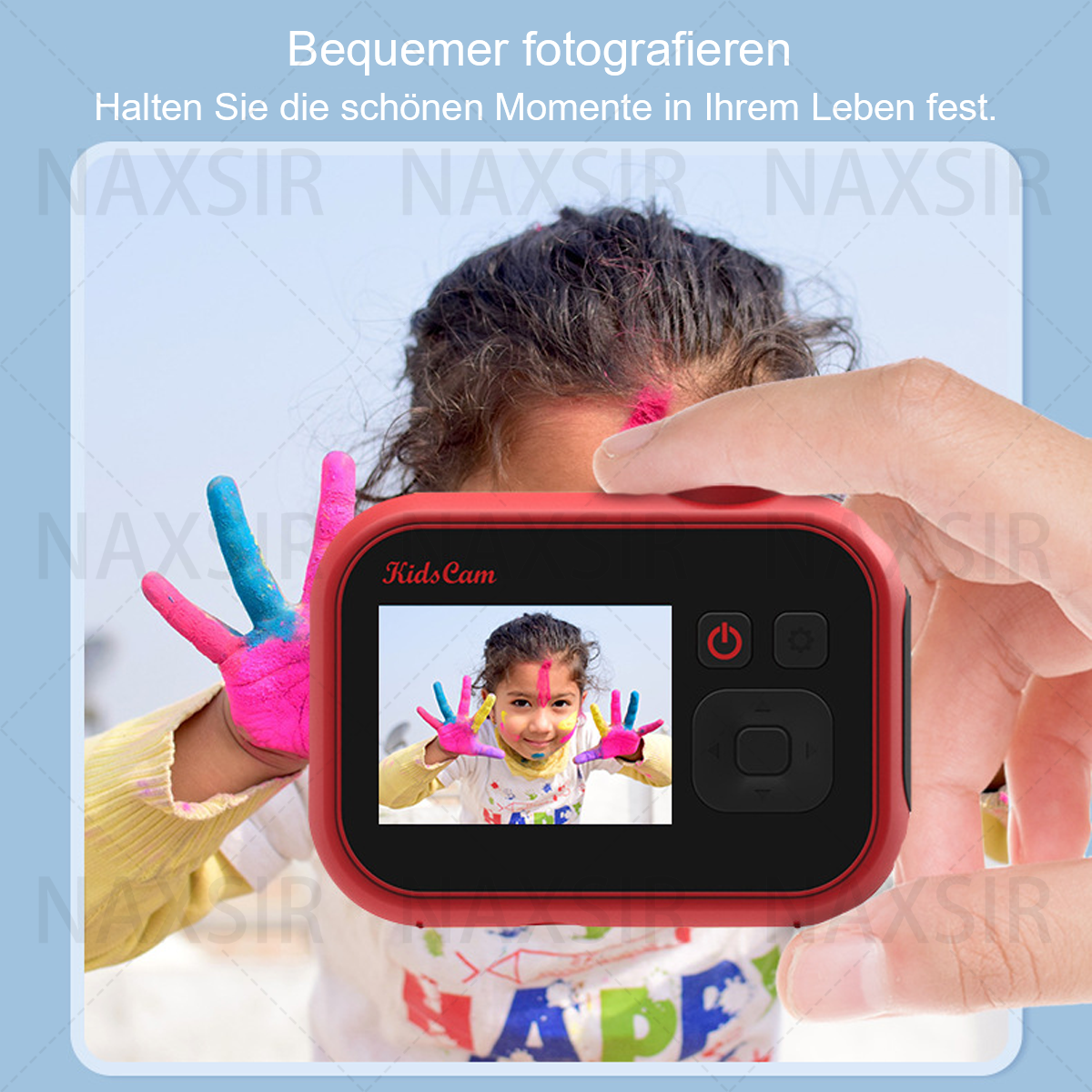 Una fotocamera rossa per bambini in mano, che mostra l'immagine di un bambino sorridente con le mani colorate. Un testo è presente.