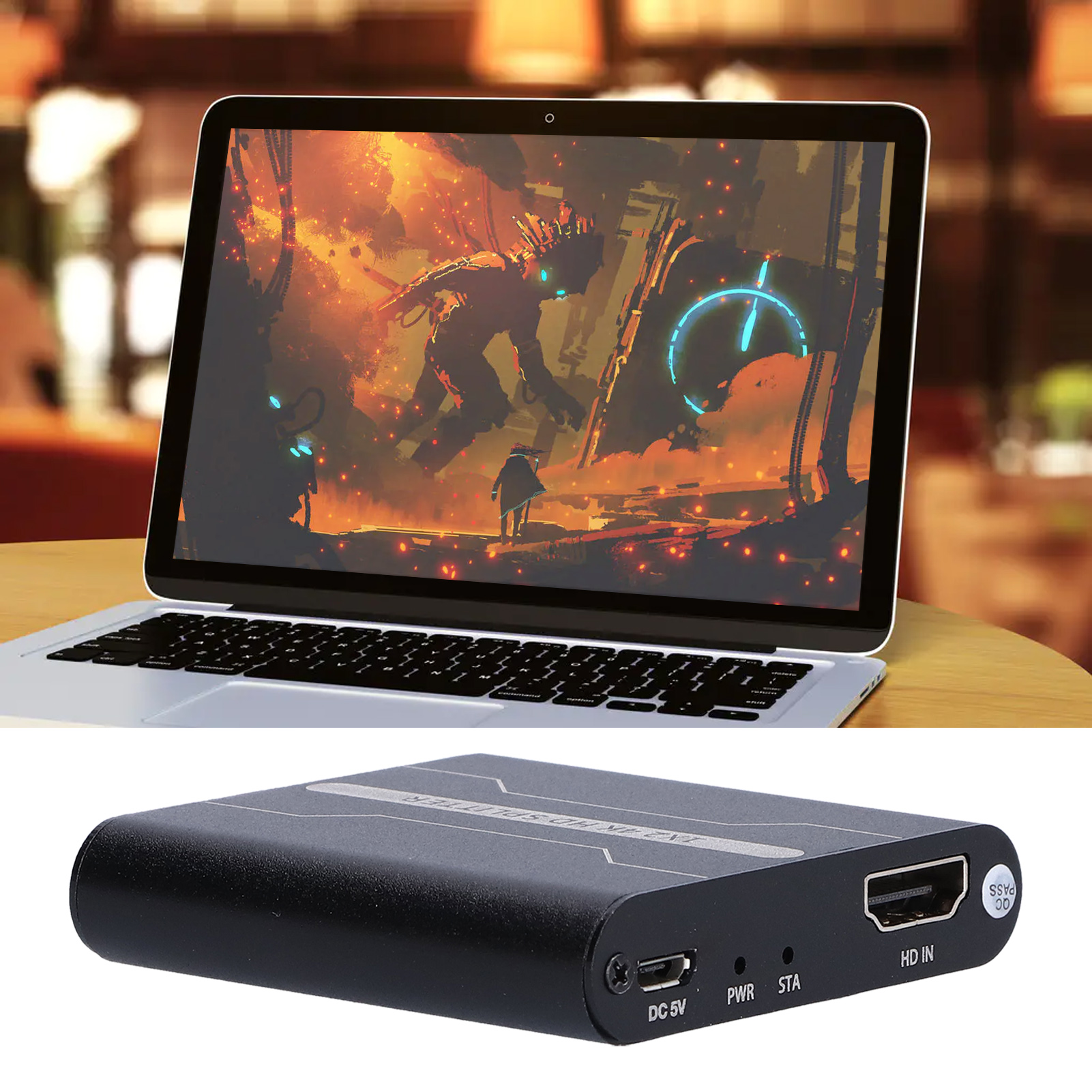 Laptop mit Spielszene und schwarzem HDMI-Gerät auf einem Holztisch.