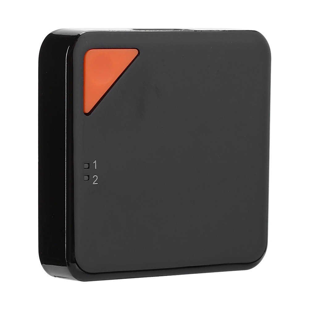Ein schwarzes, quadratisches Gerät mit einem orangefarbenen Dreiecksknopf und zwei nummerierten Quadraten.