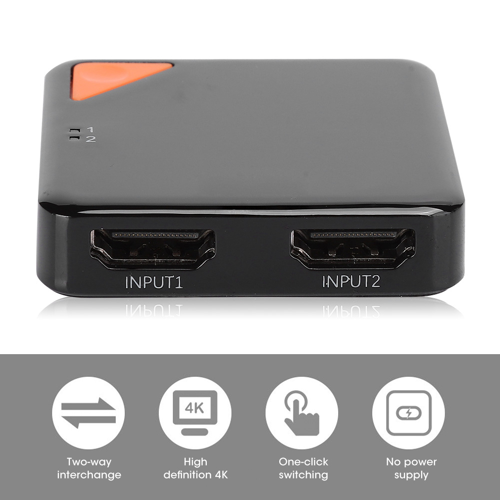 Ein schwarzer HDMI-Switch mit orangefarbenem Knopf und Eingangs-/Ausgangsbezeichnungen. Er hat Symbole für Zwei-Wege-Austausch, 4K, Umschaltung und Strom.