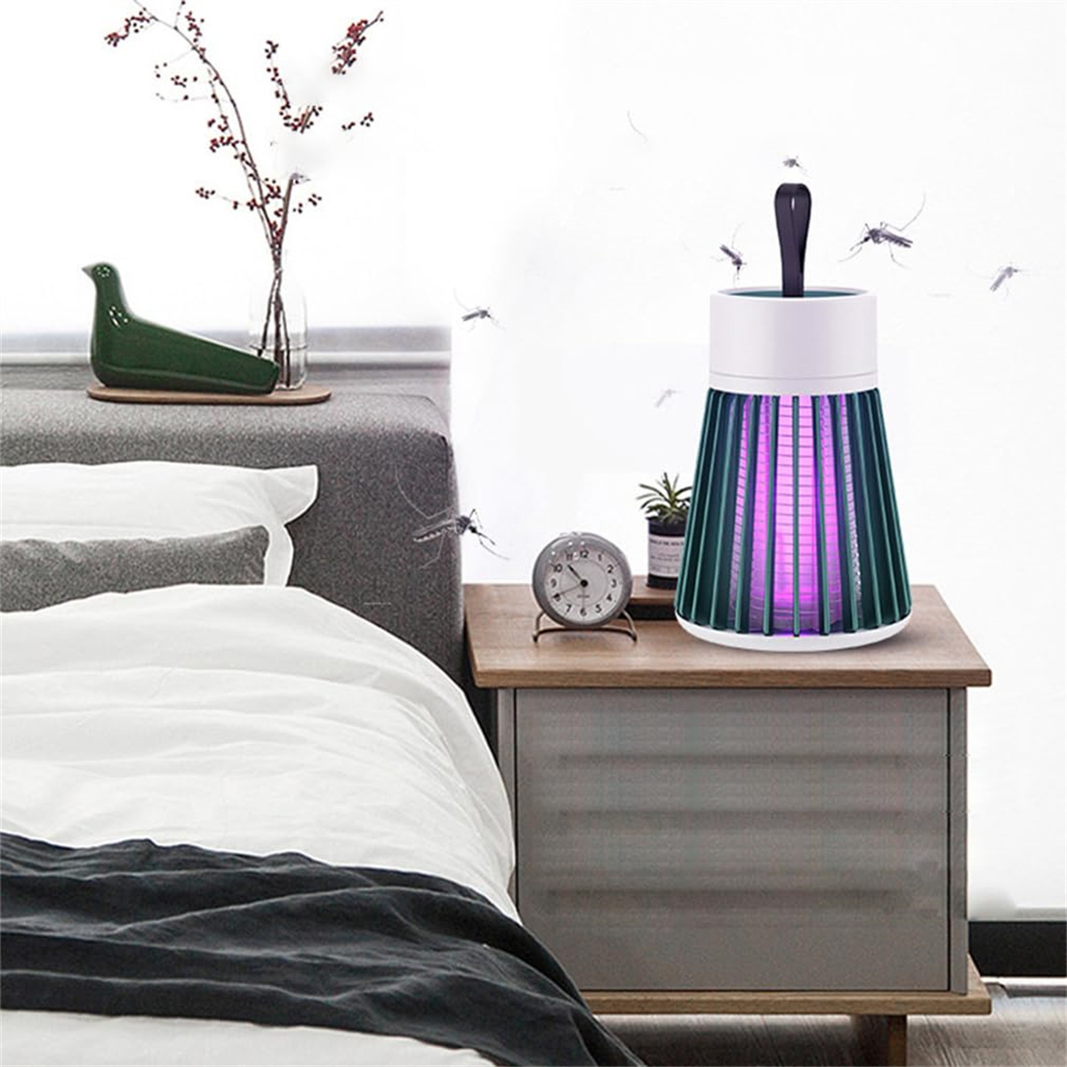 Ein Moskitofänger auf einem Nachttisch neben einem Bett. Der Zapper emittiert violettes Licht.