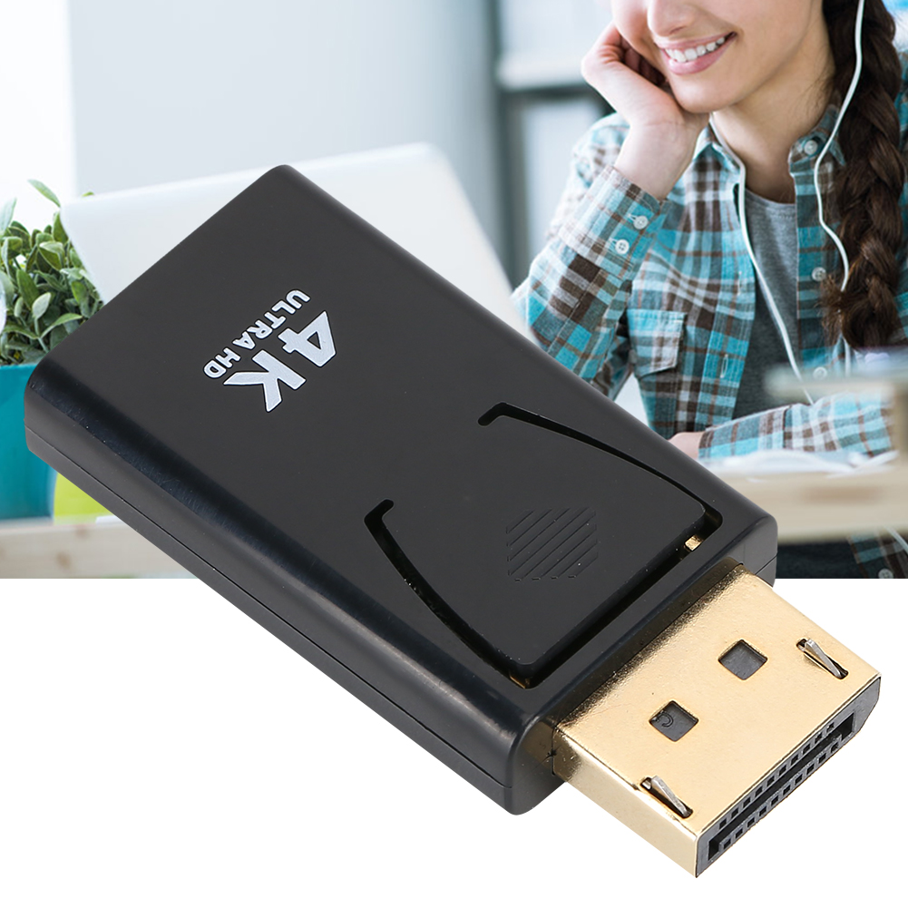 Schwarzer Adapter mit goldenem DisplayPort, beschriftet mit „4K Ultra HD“, Person im Hintergrund.