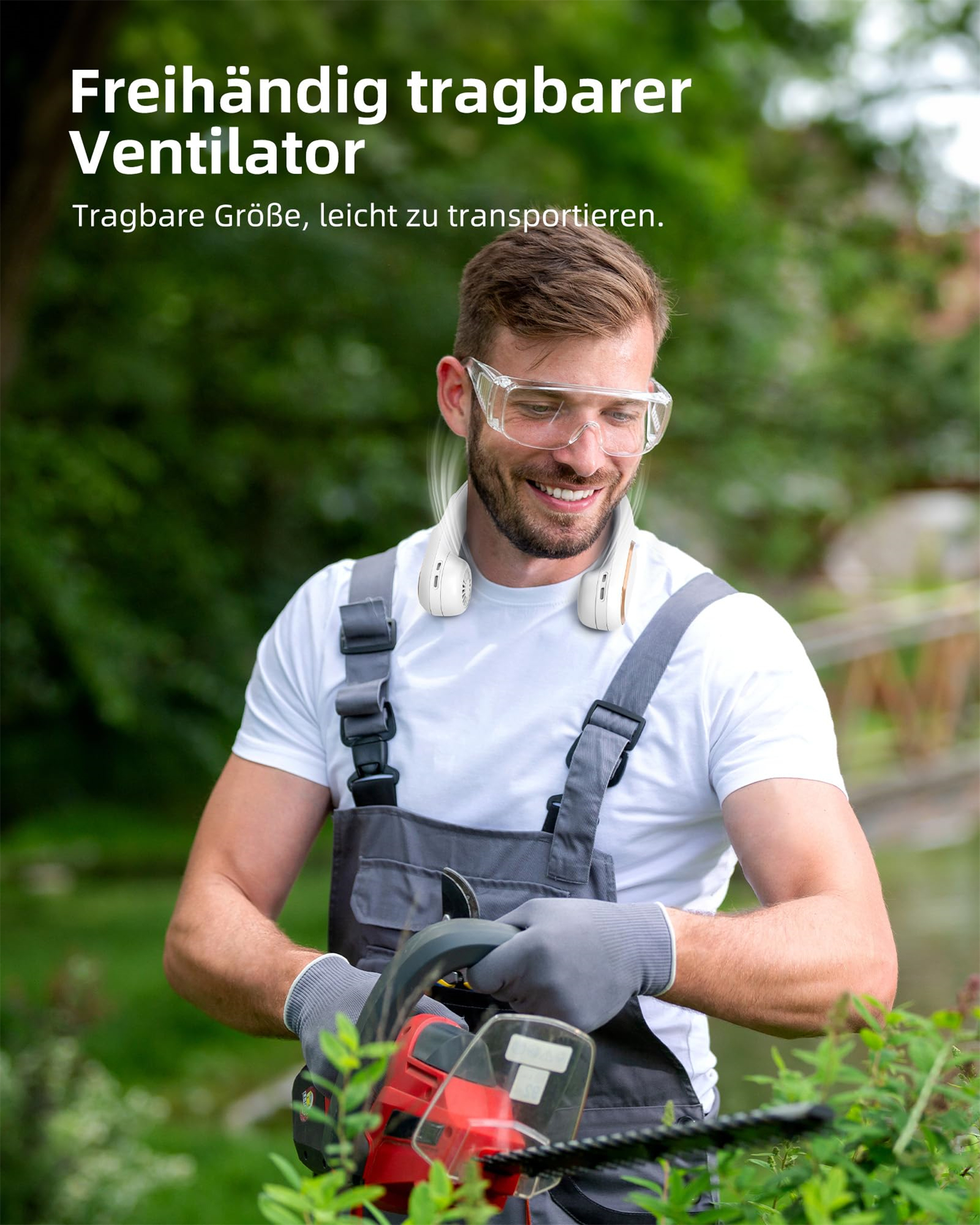 Mann lächelt, während er einen Nackenventilator benutzt, Schutzbrille und Arbeitskleidung trägt.