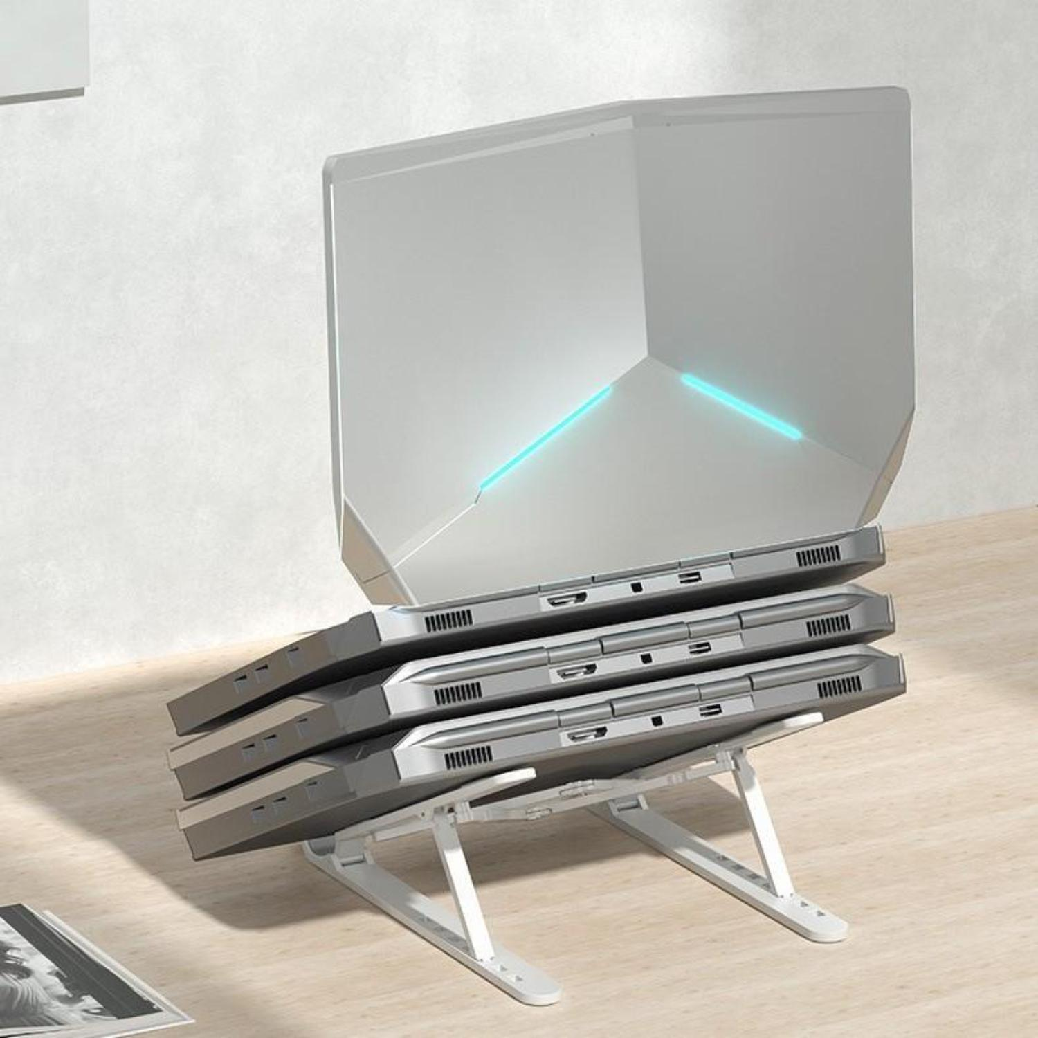 Silberne Laptops auf einem weißen Laptop-Ständer gestapelt. Blauer Leuchtstreifen. Holztisch und weiße Wand.