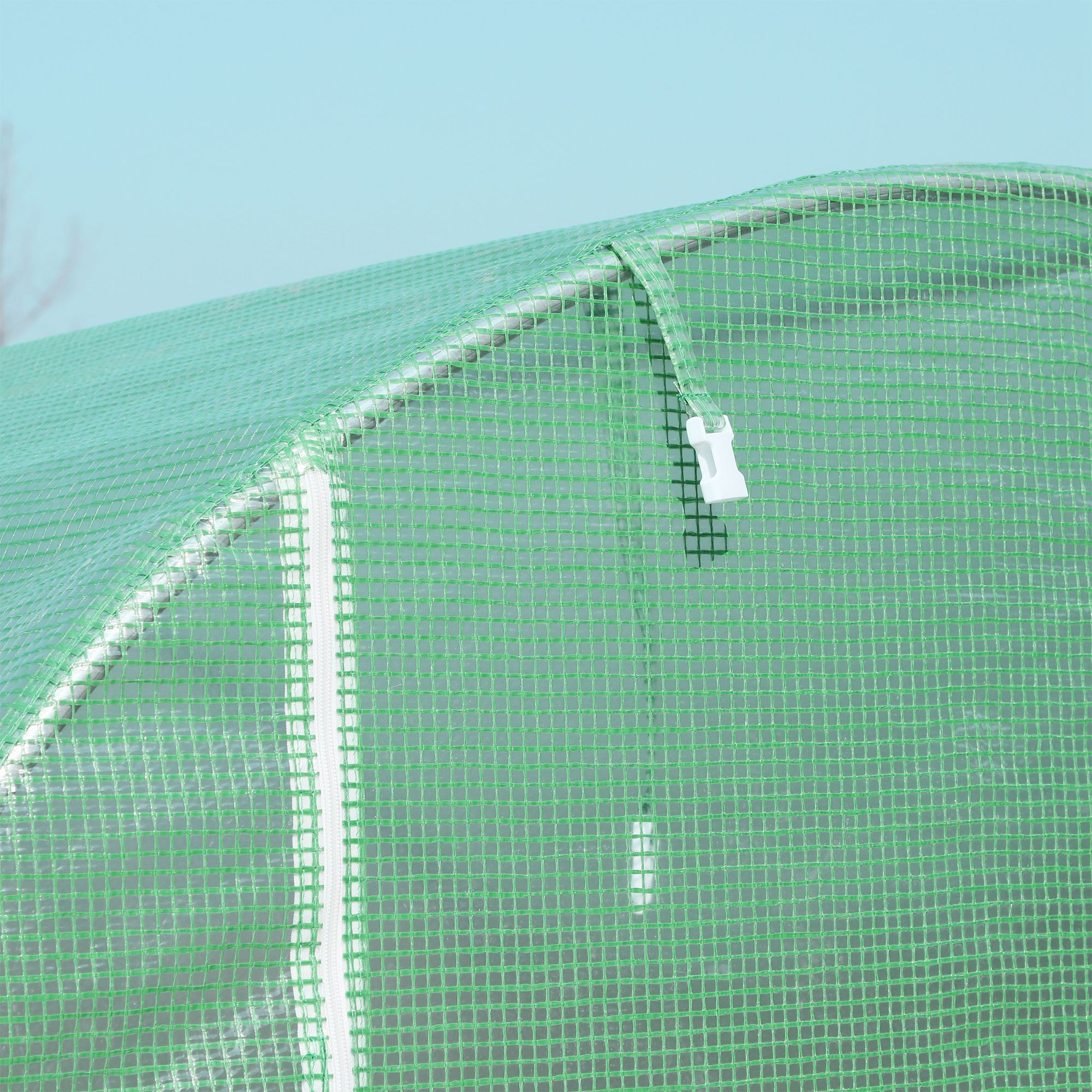 Primer plano de un invernadero verde con plástico transparente y un cierre blanco.