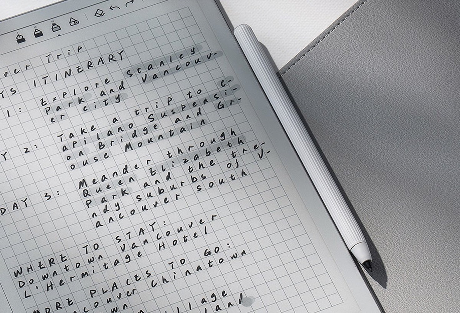 Een tablet met handgeschreven notities en een stylus. De notities lijken een reisroute te zijn met een rasterachtergrond.