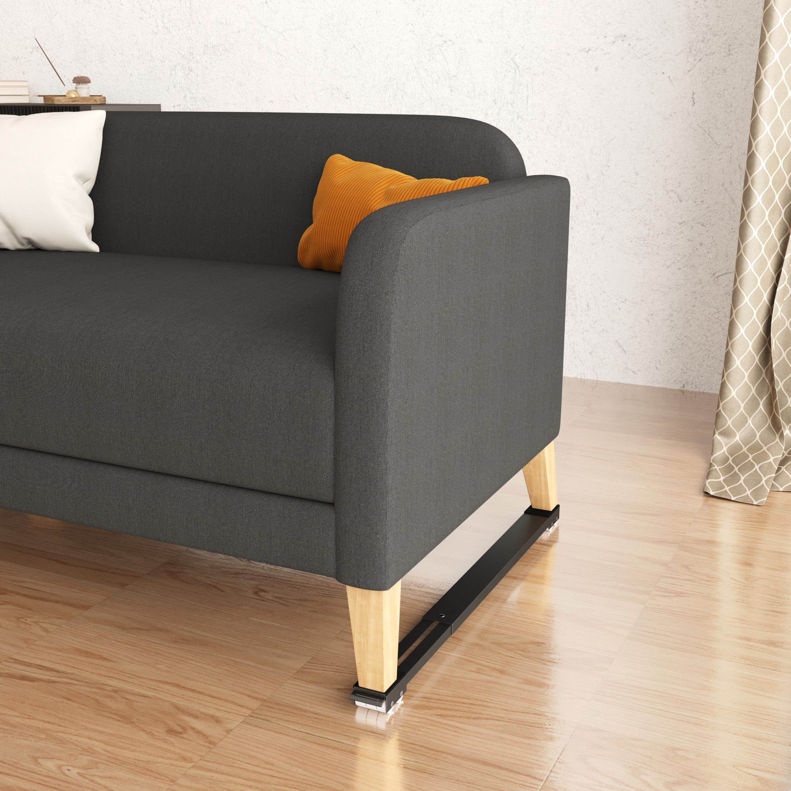 A grey sofa with two pillows and wooden legs. There is a curtain and floor in the background.