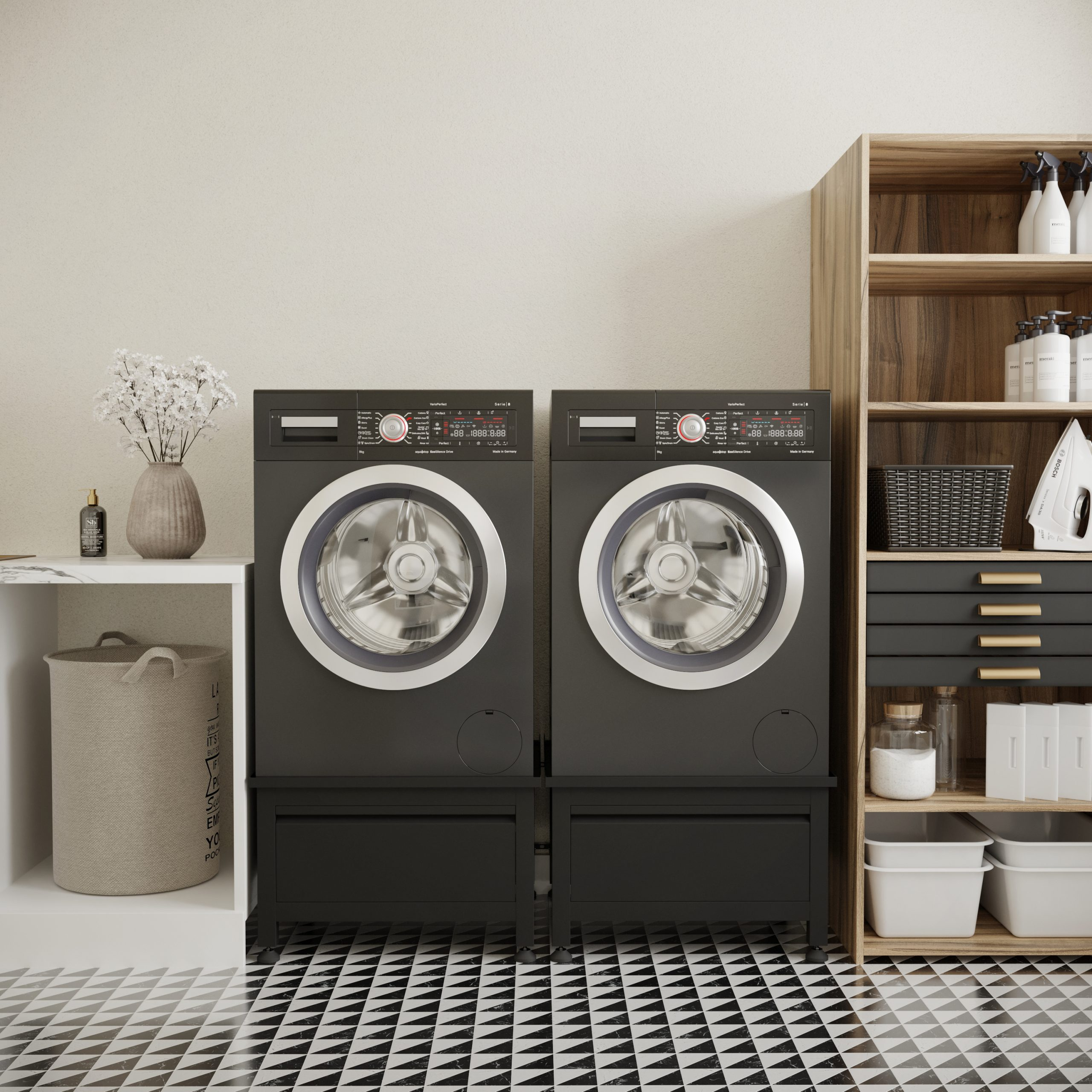 A laundry room with two black washing machines and a cabinet. The room has a patterned floor.