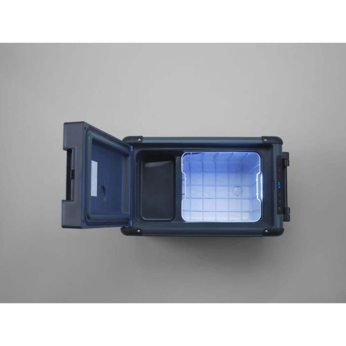 Otwarta przenośna chłodziarka, drzwi po lewej. Wnętrze oświetlone niebieskim światłem. Ciemna obudowa, szare tło, widok z góry.