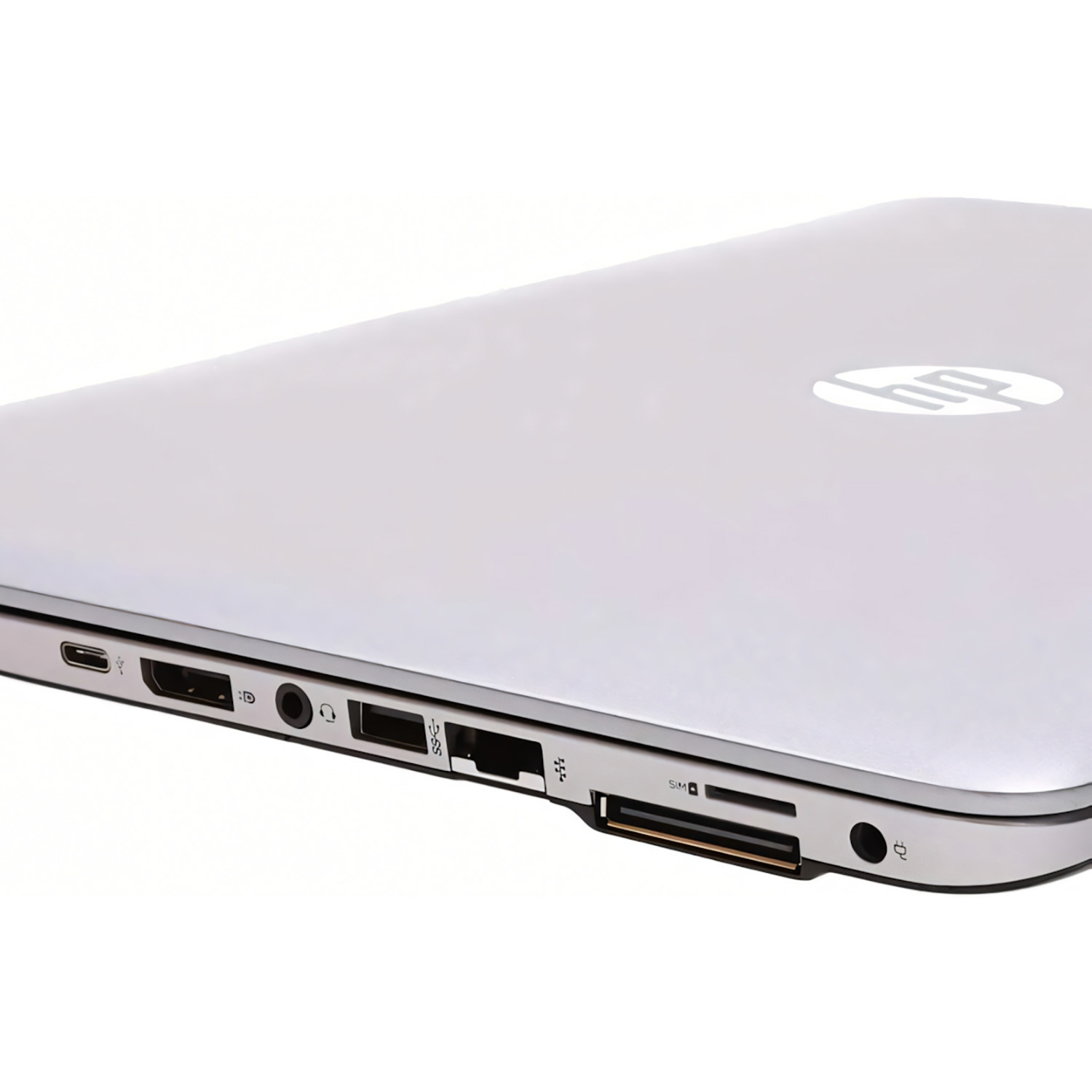 Primer plano del lateral de un portátil plateado. Muestra puertos: USB, auriculares, carga y ranura SIM.
