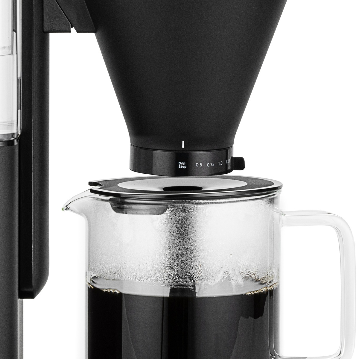 Eine Kaffeemaschine mit schwarzen und transparenten Teilen. Kaffee wird in der Glaskaraffe gebrüht. Eine Skala befindet sich an der Seite.