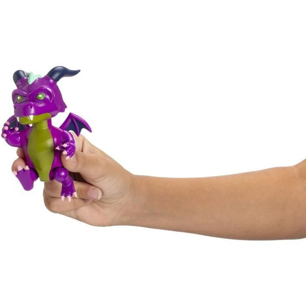 Spielzeugdrache in der Hand gehalten. Drache ist lila und grün. Weißer Hintergrund. Flügel und Krallen sichtbar.