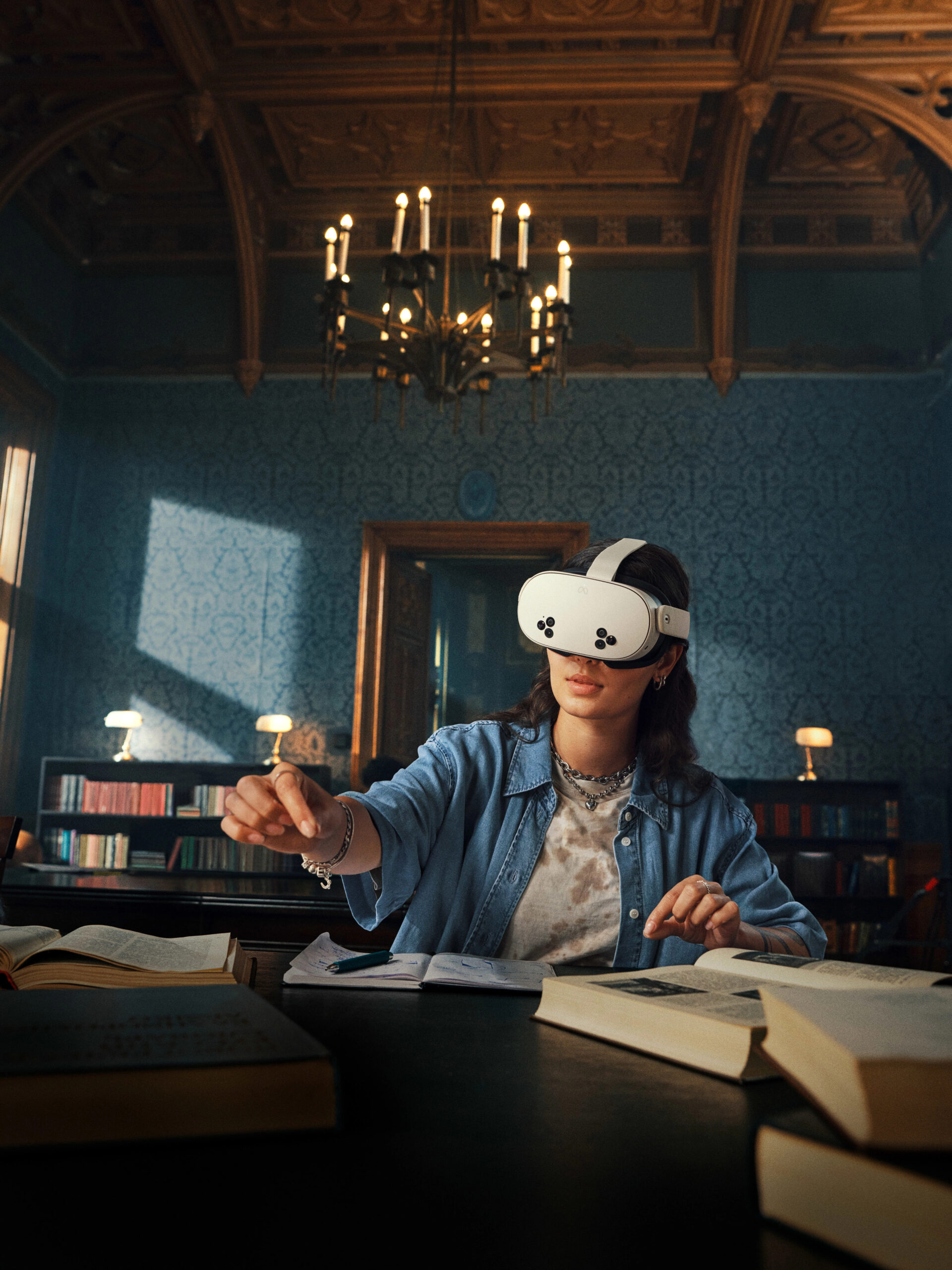 Donna che indossa un visore VR a una scrivania con libri in una biblioteca, mostrando la realtà aumentata nell'istruzione.