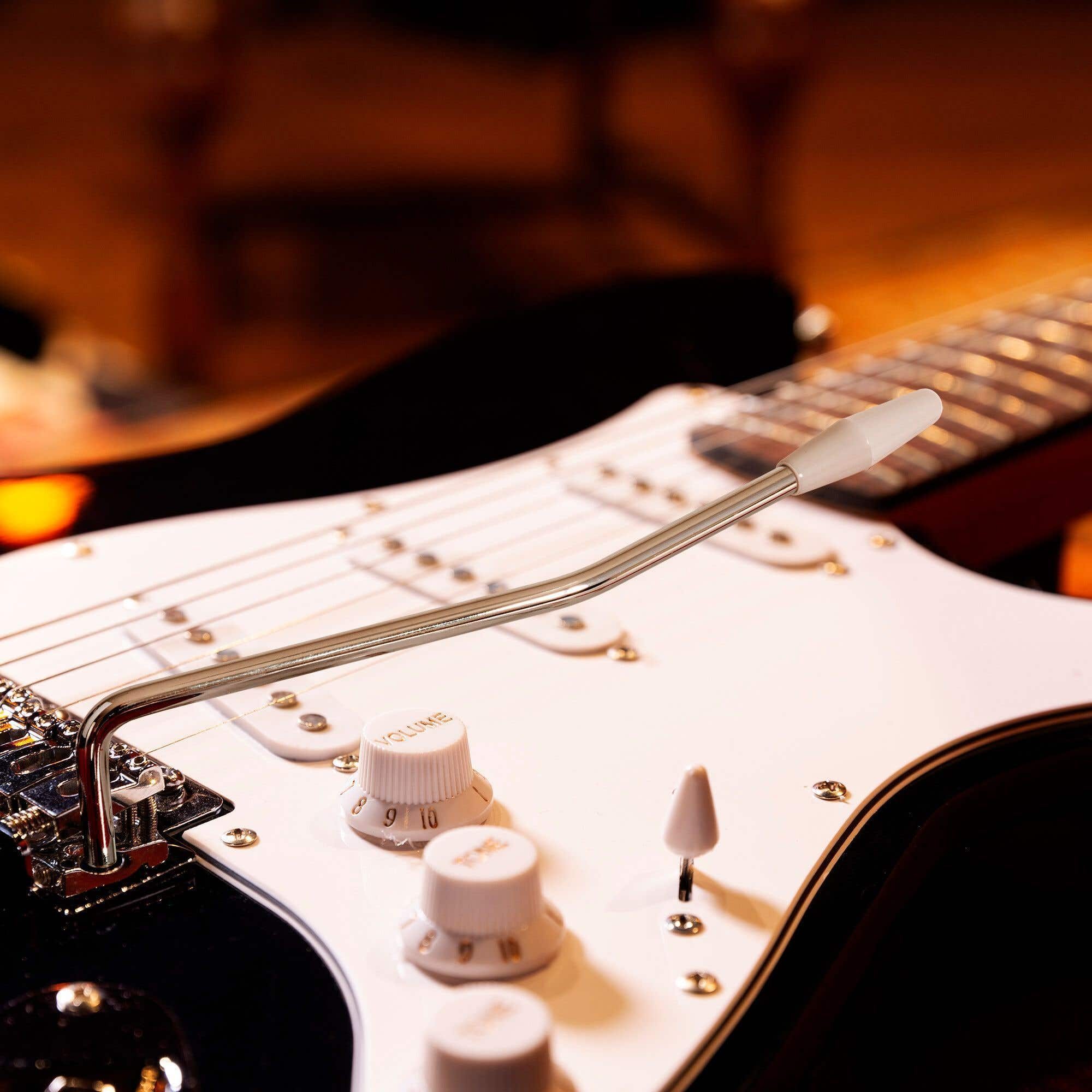 E-Gitarre mit weißem Schlagbrett, Chrom-Hardware und Tremolo-Hebel.