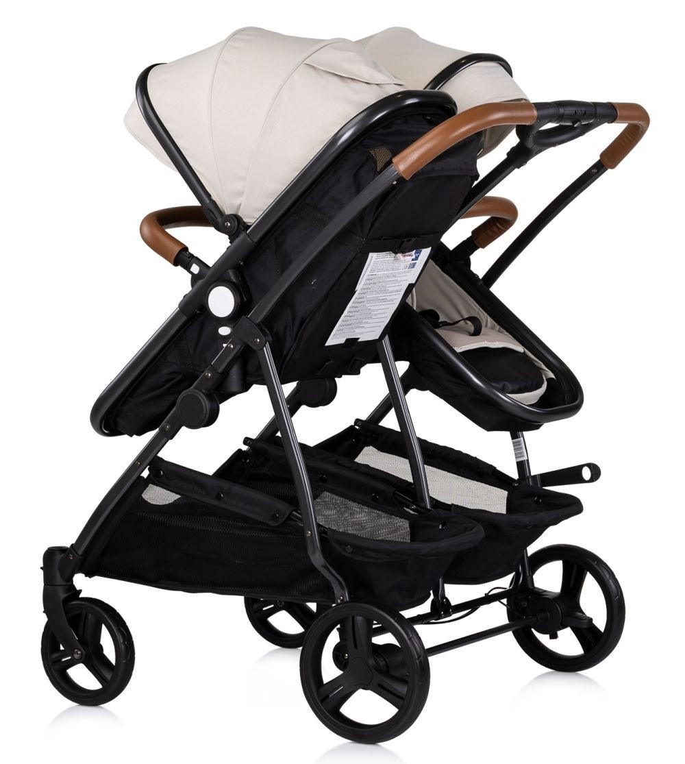 Doppelkinderwagen mit beigefarbenen Verdecken, braunen Griffen, schwarzem Rahmen und schwarzen Körben.
